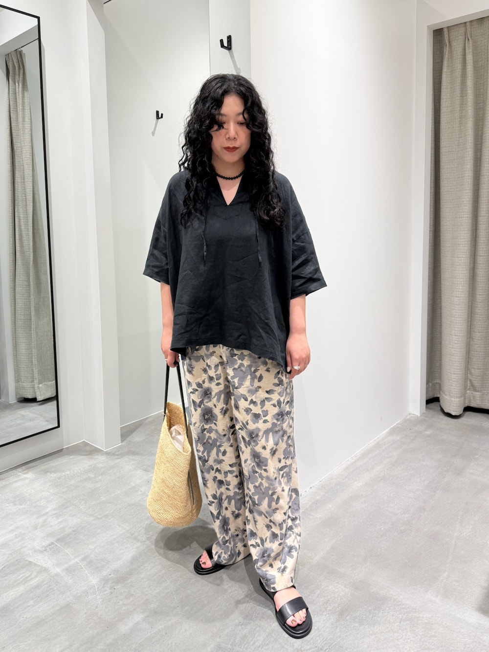 グレー系のその他パンツ、ベージュ系のかごバッグ、ブラック系のサンダルを着用したレディースの春コーディネートの4枚目の写真