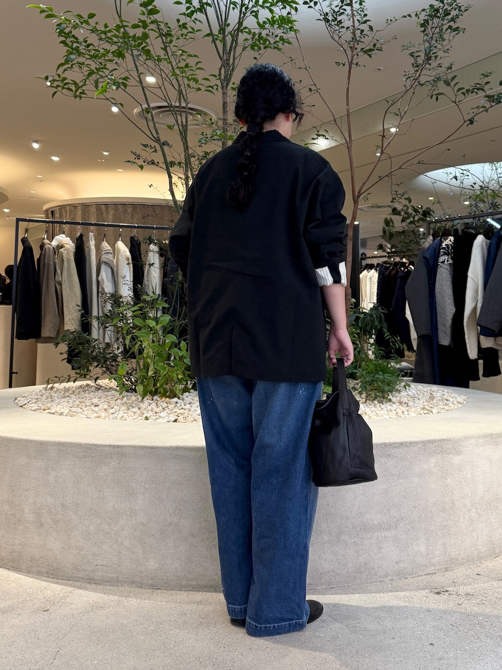 ブルー系のデニムパンツ、ブラック系のバッグ、ブラック系のその他アウターを着用したレディースの秋コーディネートの3枚目の写真