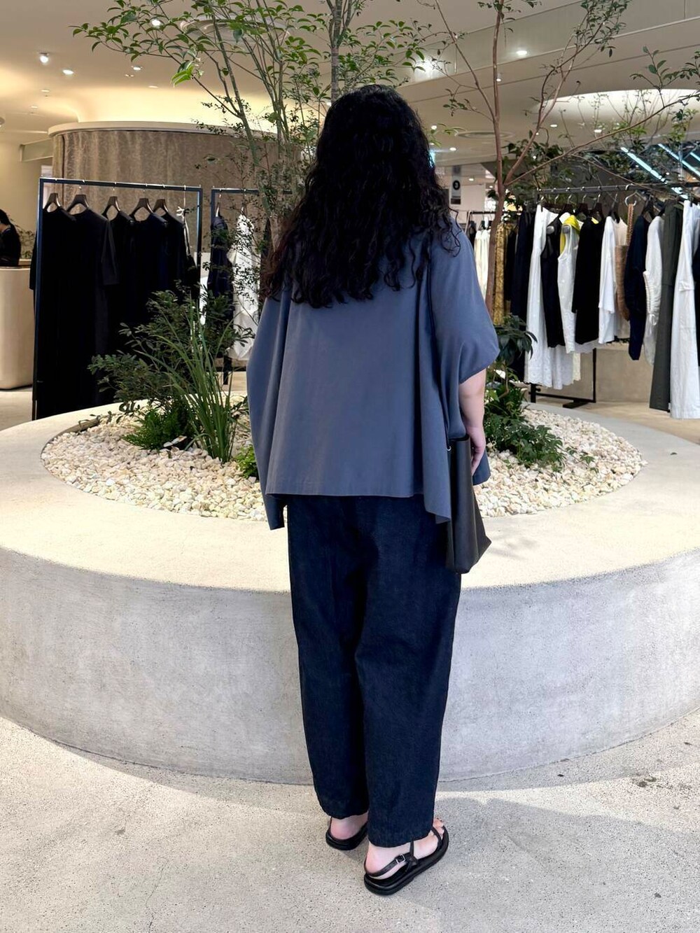 ブルー系のデニムパンツ、グレー系のシャツ/ブラウス、ブラック系のバッグを着用したレディースの夏コーディネートの3枚目の写真