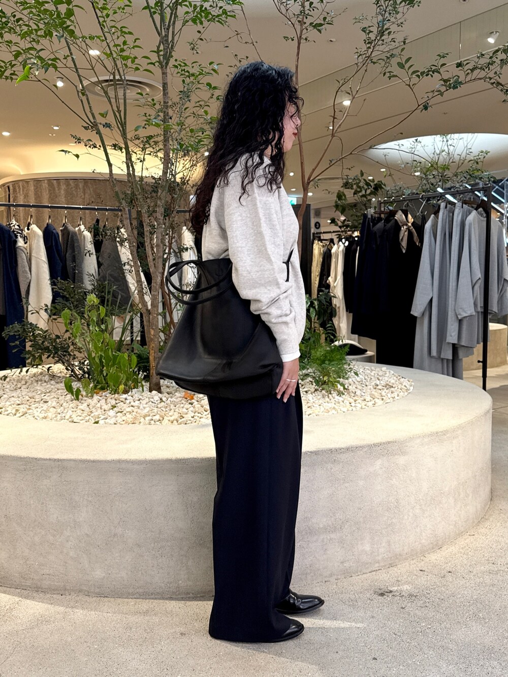 グレー系のスウェット、ホワイト系のTシャツ/カットソー、ブラック系のトートバッグを着用したレディースの秋コーディネートの2枚目の写真