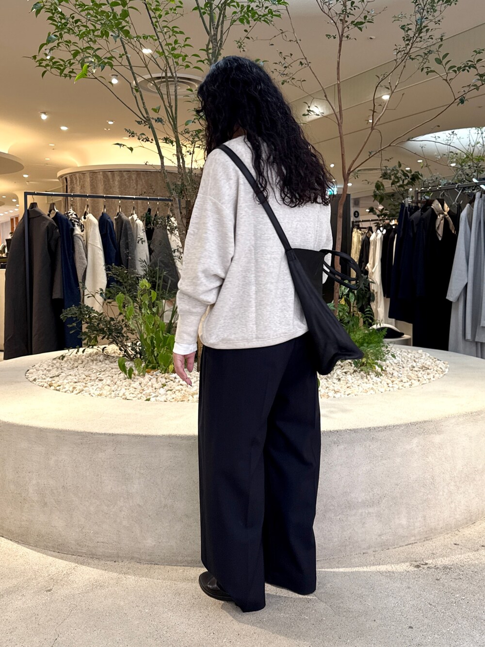 グレー系のスウェット、ホワイト系のTシャツ/カットソー、ブラック系のトートバッグを着用したレディースの秋コーディネートの4枚目の写真