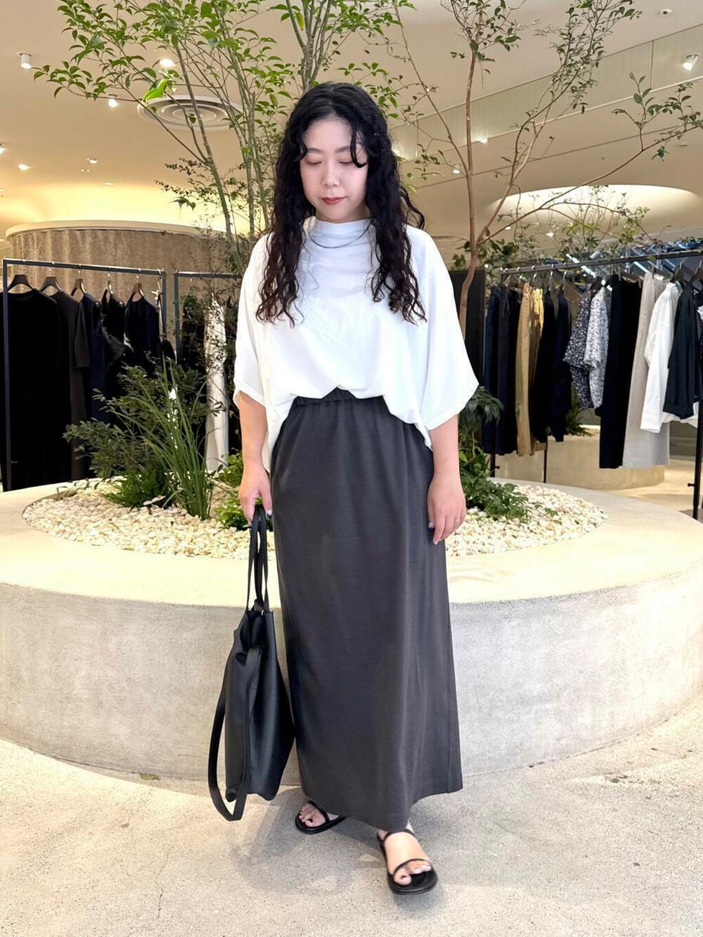 ホワイト系のTシャツ/カットソー、グレー系のスカート、ブラック系のバッグを着用したレディースの夏コーディネートの4枚目の写真
