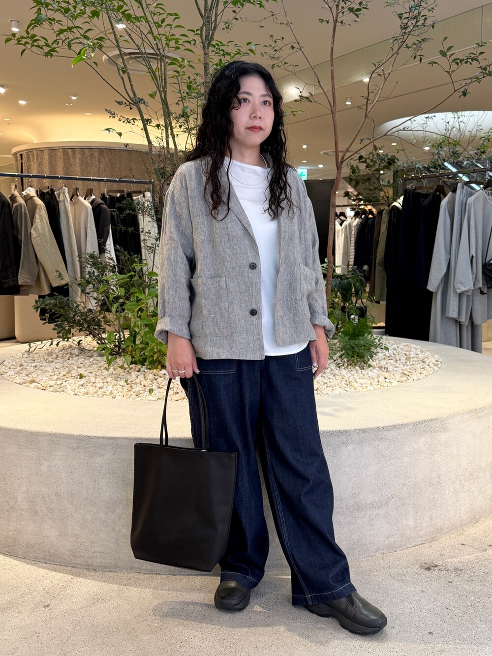 ブラック系のトートバッグ、ホワイト系のTシャツ/カットソー、ブルー系のその他パンツを着用したレディースの秋コーディネートの5枚目の写真