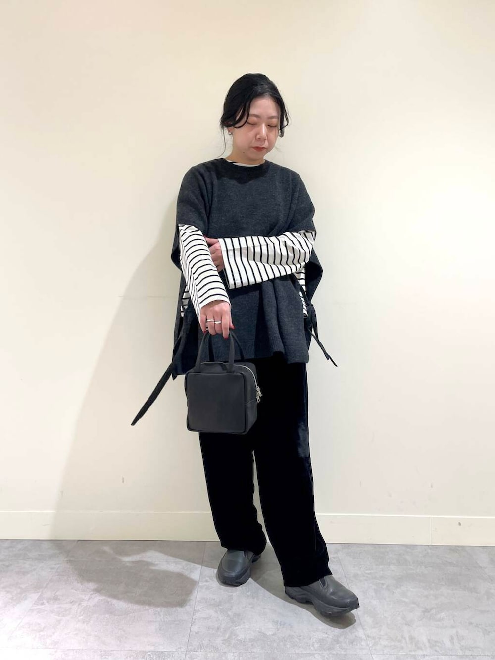 ブラック系のその他パンツ、ホワイト系のTシャツ/カットソー、グレー系のベストを着用したレディースの冬コーディネートの4枚目の写真