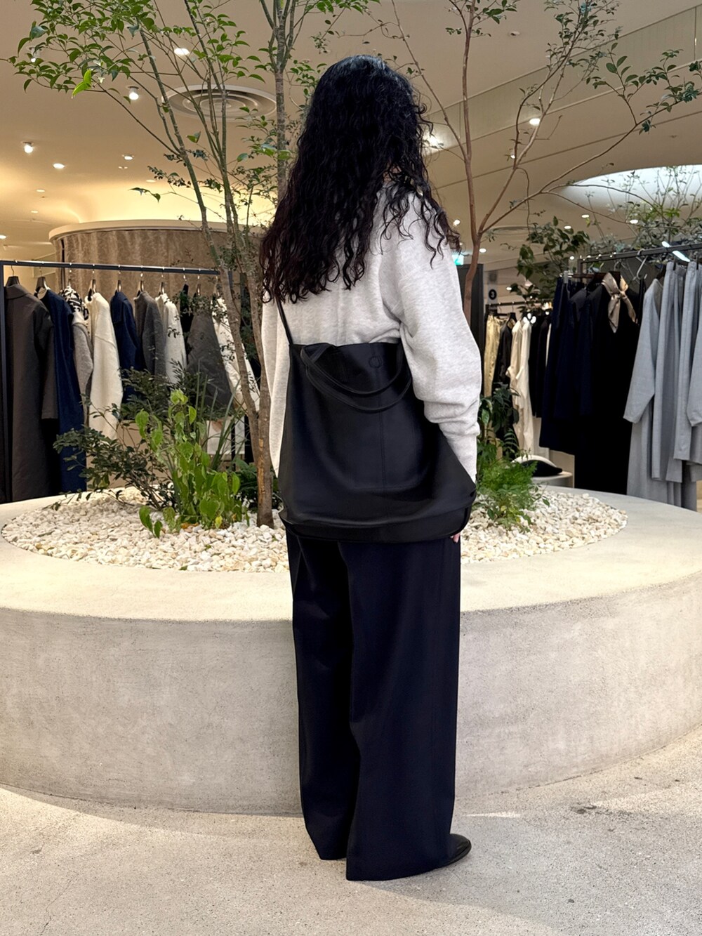 グレー系のスウェット、ホワイト系のTシャツ/カットソー、ブラック系のトートバッグを着用したレディースの秋コーディネートの3枚目の写真