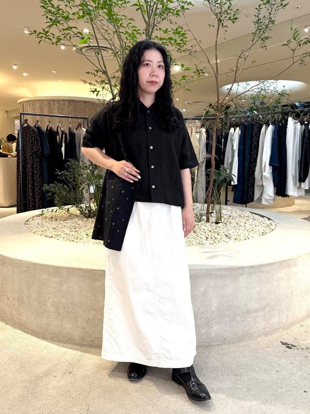 ホワイト系のスカート、ブラック系のシャツ/ブラウスを着用したレディースの春コーディネートの5枚目の写真