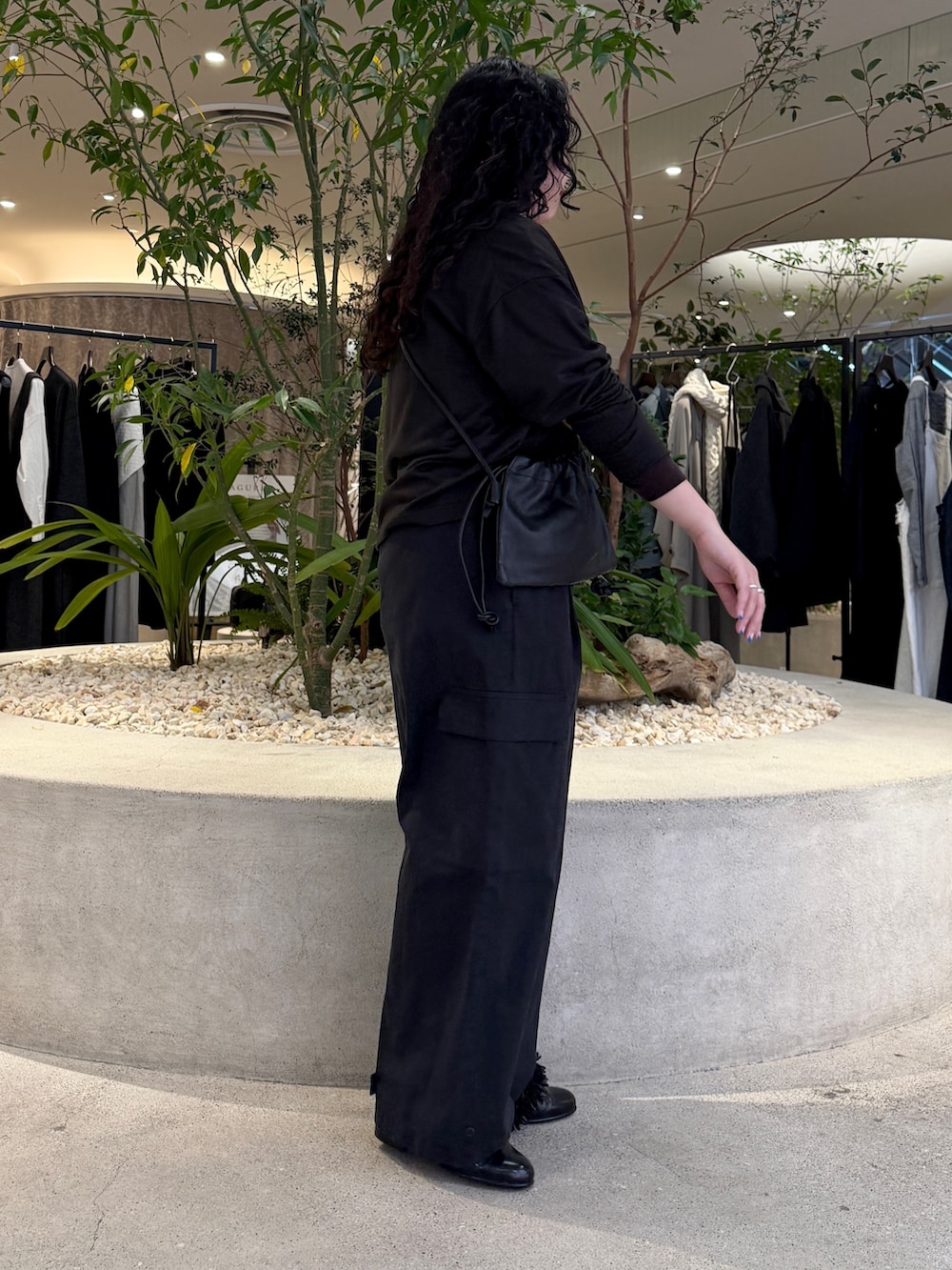 ブラック系のショルダーバッグ、ブラウン系のTシャツ/カットソー、ブラウン系のシャツ/ブラウスを着用したレディースの冬コーディネートの2枚目の写真