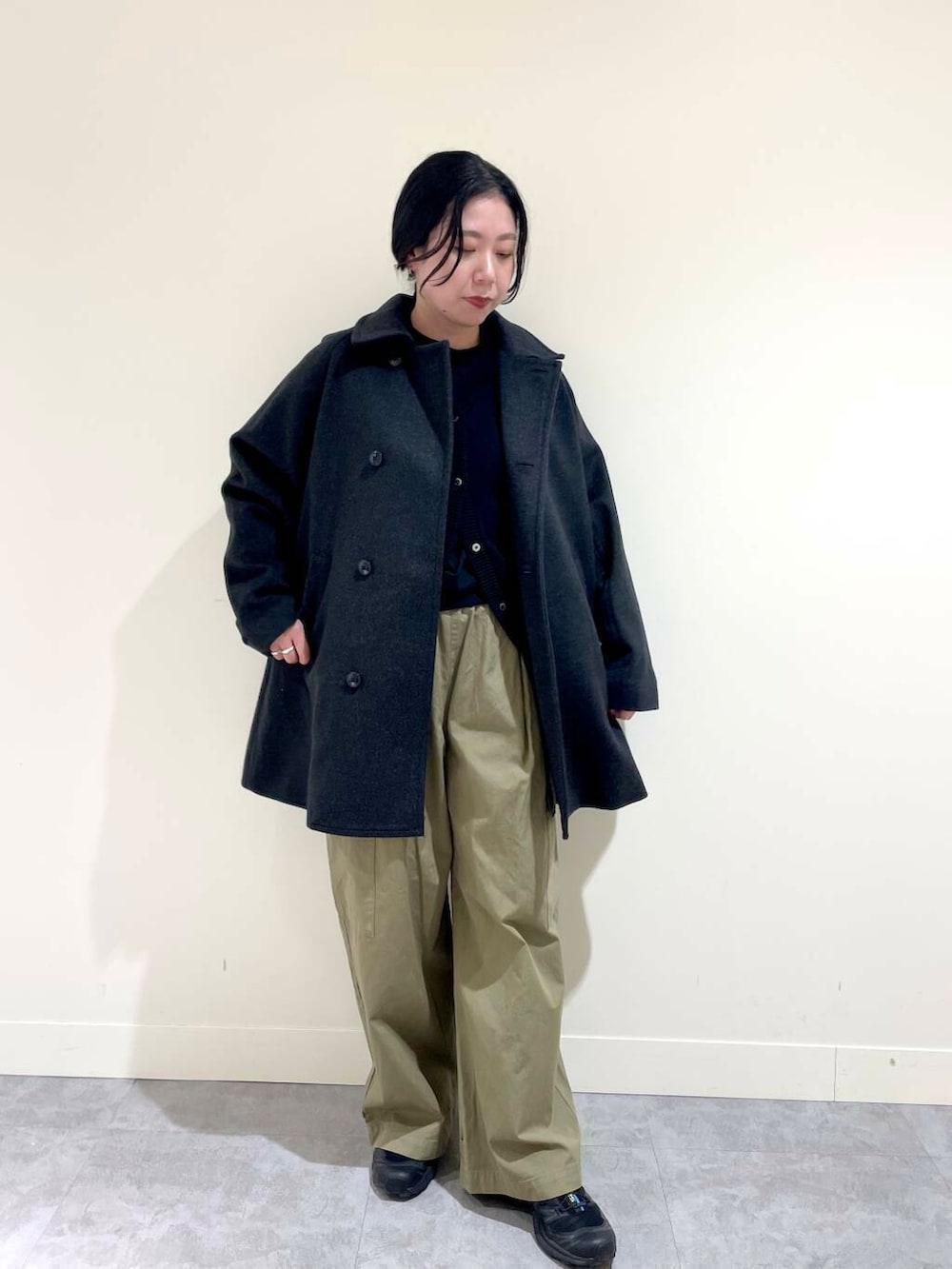 グリーン系のその他パンツ、ブラック系のベスト、グレー系のピーコートを着用したレディースの冬コーディネートの2枚目の写真