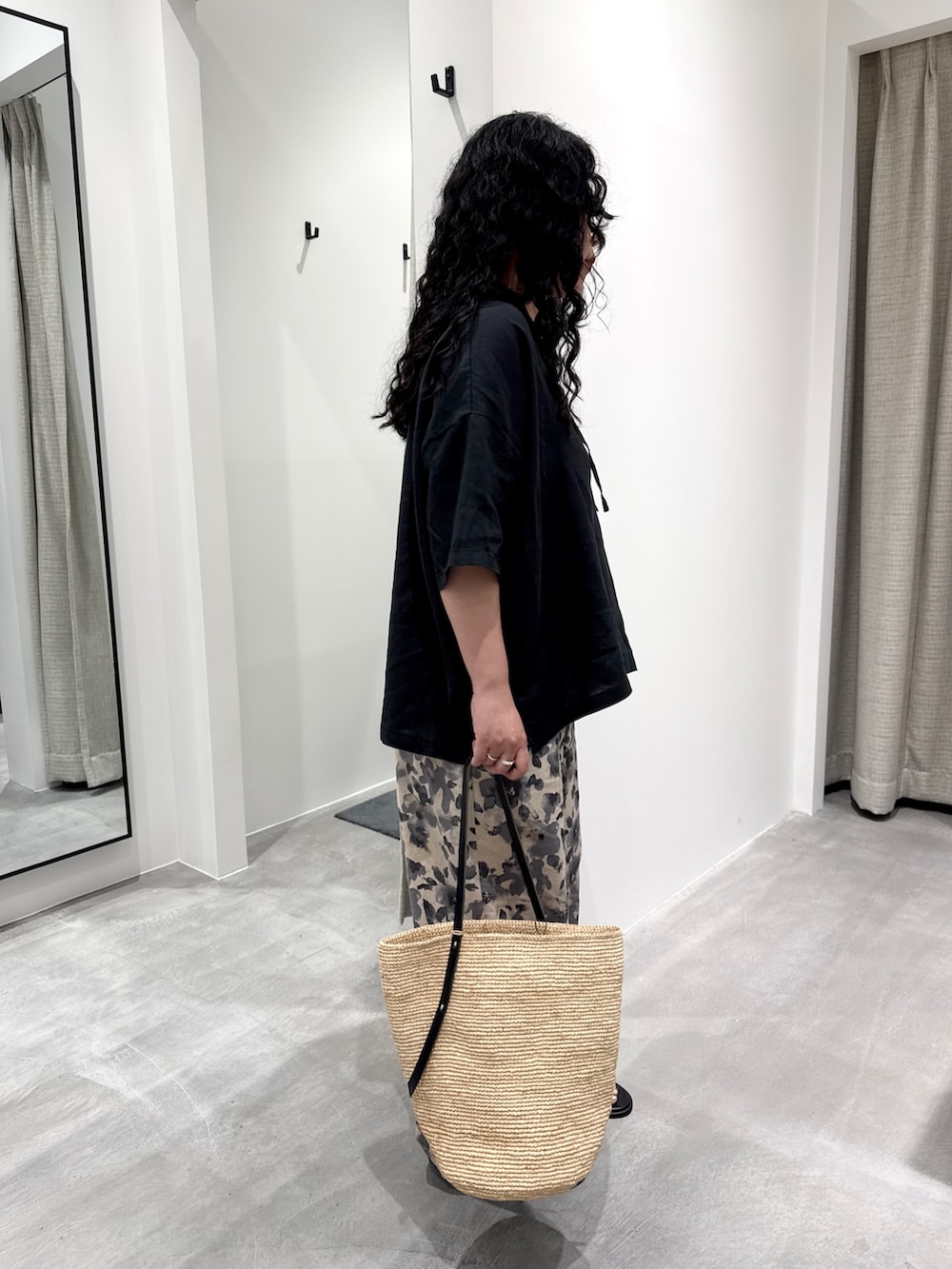 グレー系のその他パンツ、ベージュ系のかごバッグ、ブラック系のサンダルを着用したレディースの春コーディネートの2枚目の写真