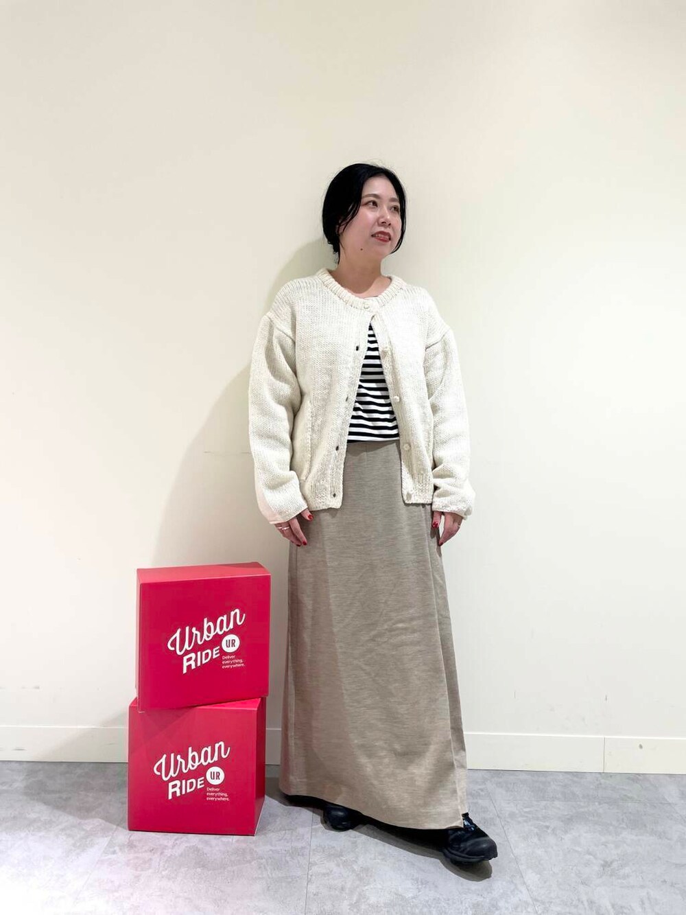 ホワイト系のニット/セーター、ブラック系のTシャツ/カットソー、ベージュ系のスカートを着用したレディースの冬コーディネートの2枚目の写真