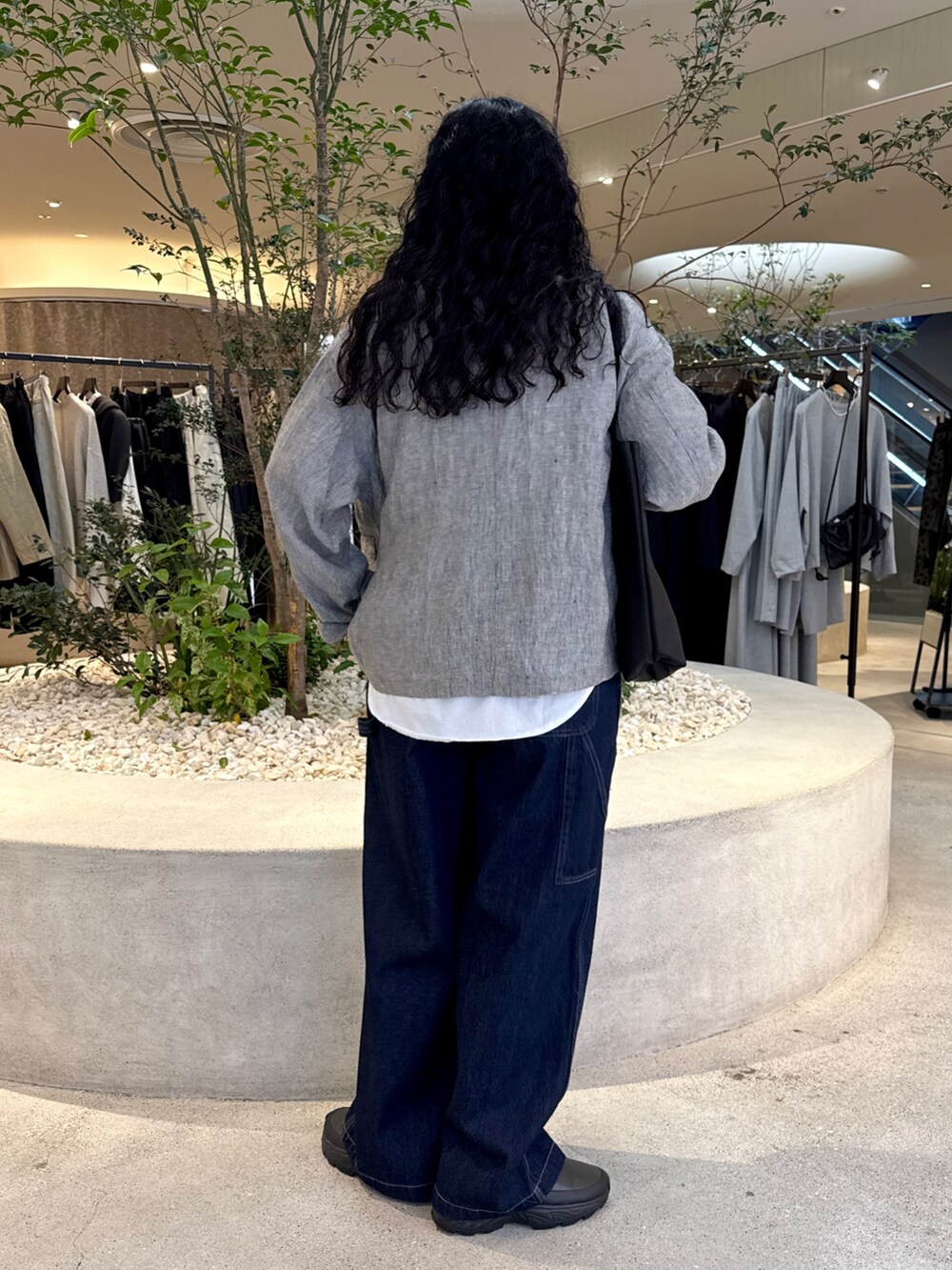 ブラック系のトートバッグ、ホワイト系のTシャツ/カットソー、ブルー系のその他パンツを着用したレディースの秋コーディネートの3枚目の写真
