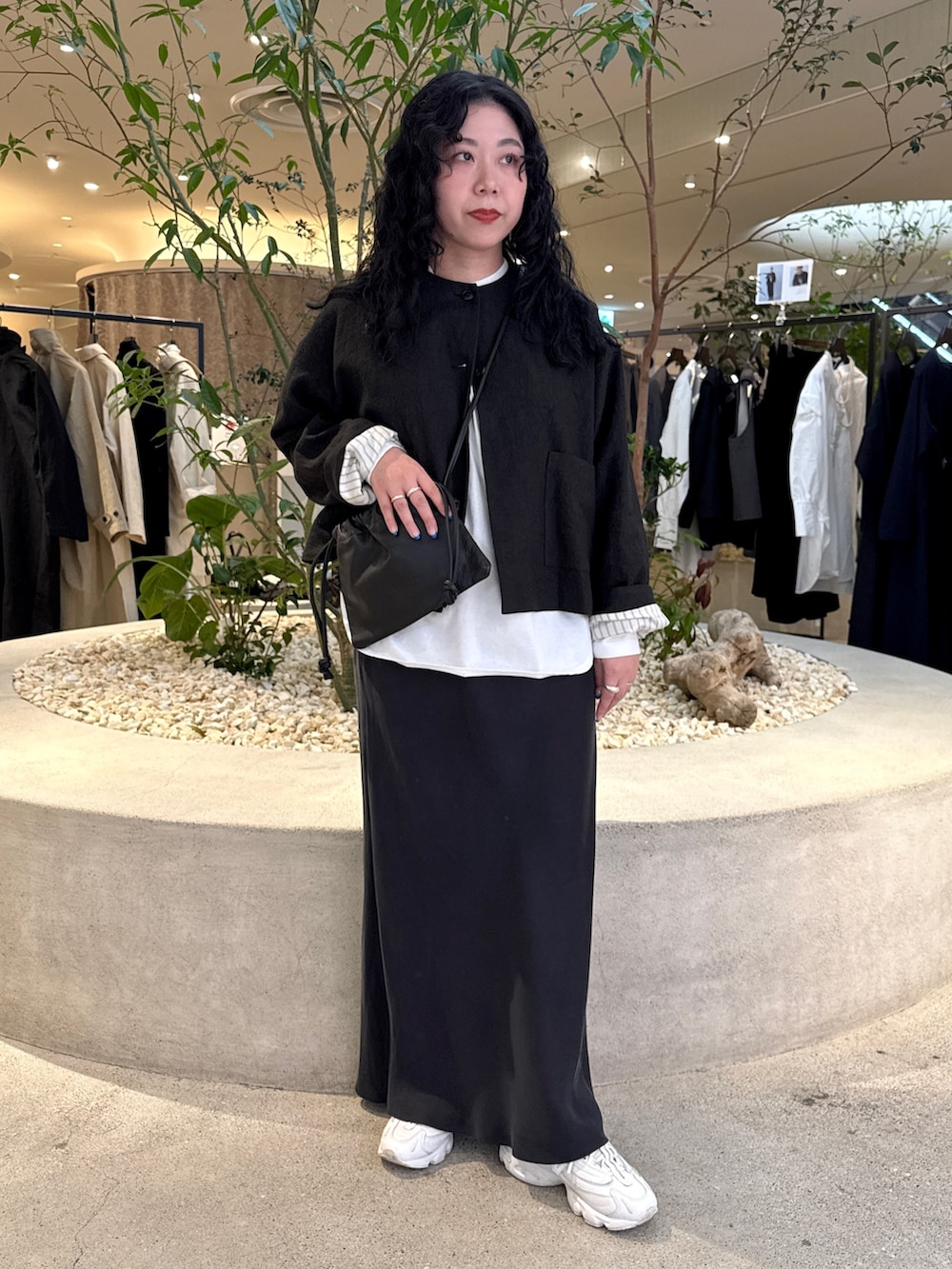 ブラック系のショルダーバッグ、ホワイト系のTシャツ/カットソー、ブラック系のノーカラージャケットを着用したレディースの冬コーディネートの5枚目の写真