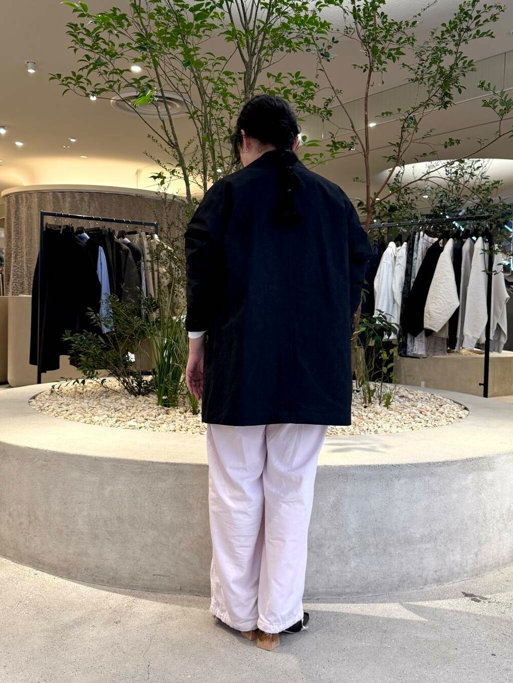 ホワイト系のニット/セーター、ブラック系のその他アウター、ピンク系のパンツを着用したレディースの春コーディネートの3枚目の写真