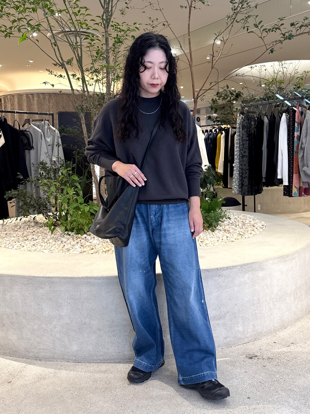 グレー系のスウェット、ブラック系のトートバッグ、ブラック系のスニーカーを着用したレディースの秋コーディネートの4枚目の写真