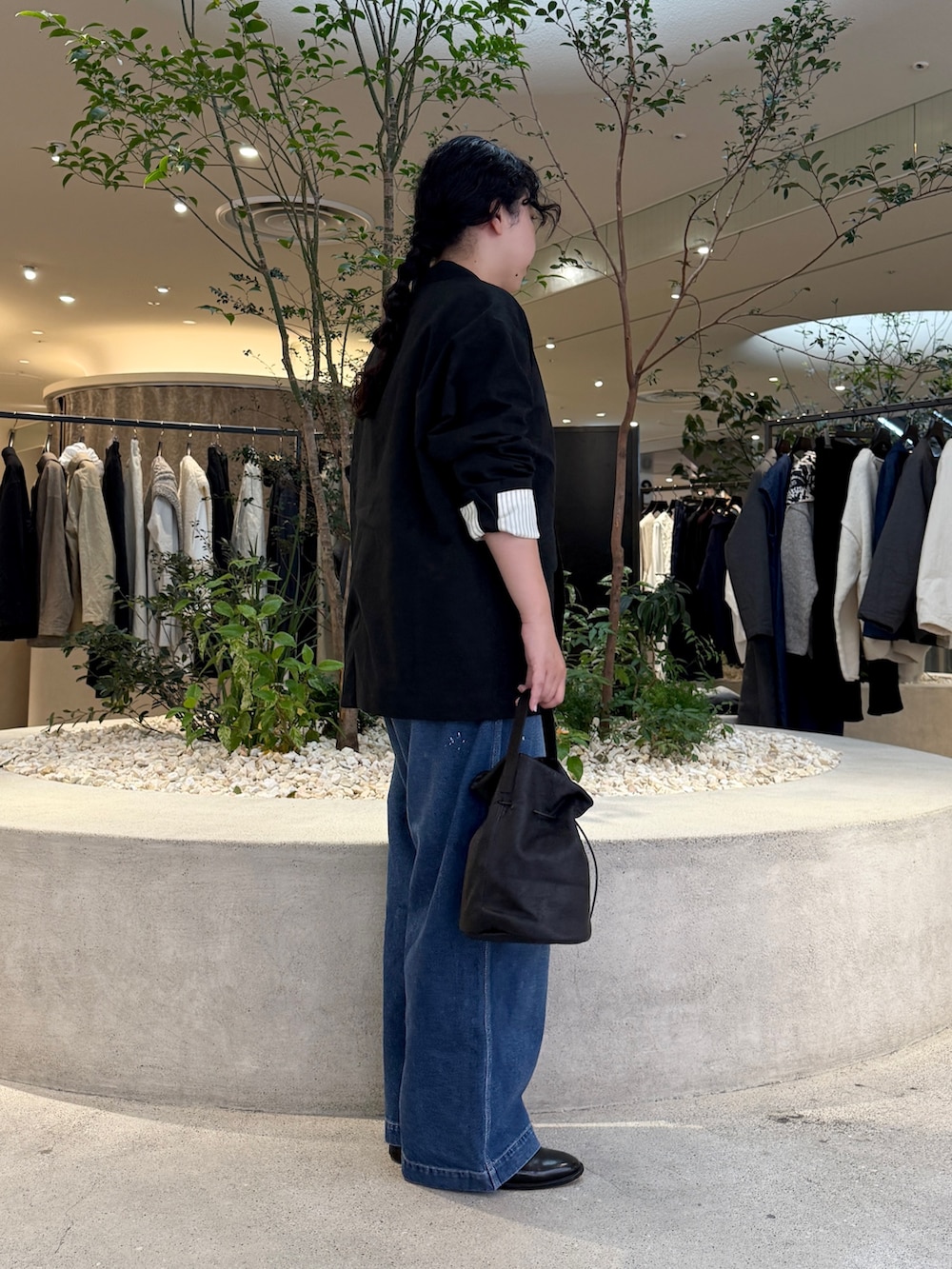 ブルー系のデニムパンツ、ブラック系のバッグ、ブラック系のその他アウターを着用したレディースの秋コーディネートの2枚目の写真