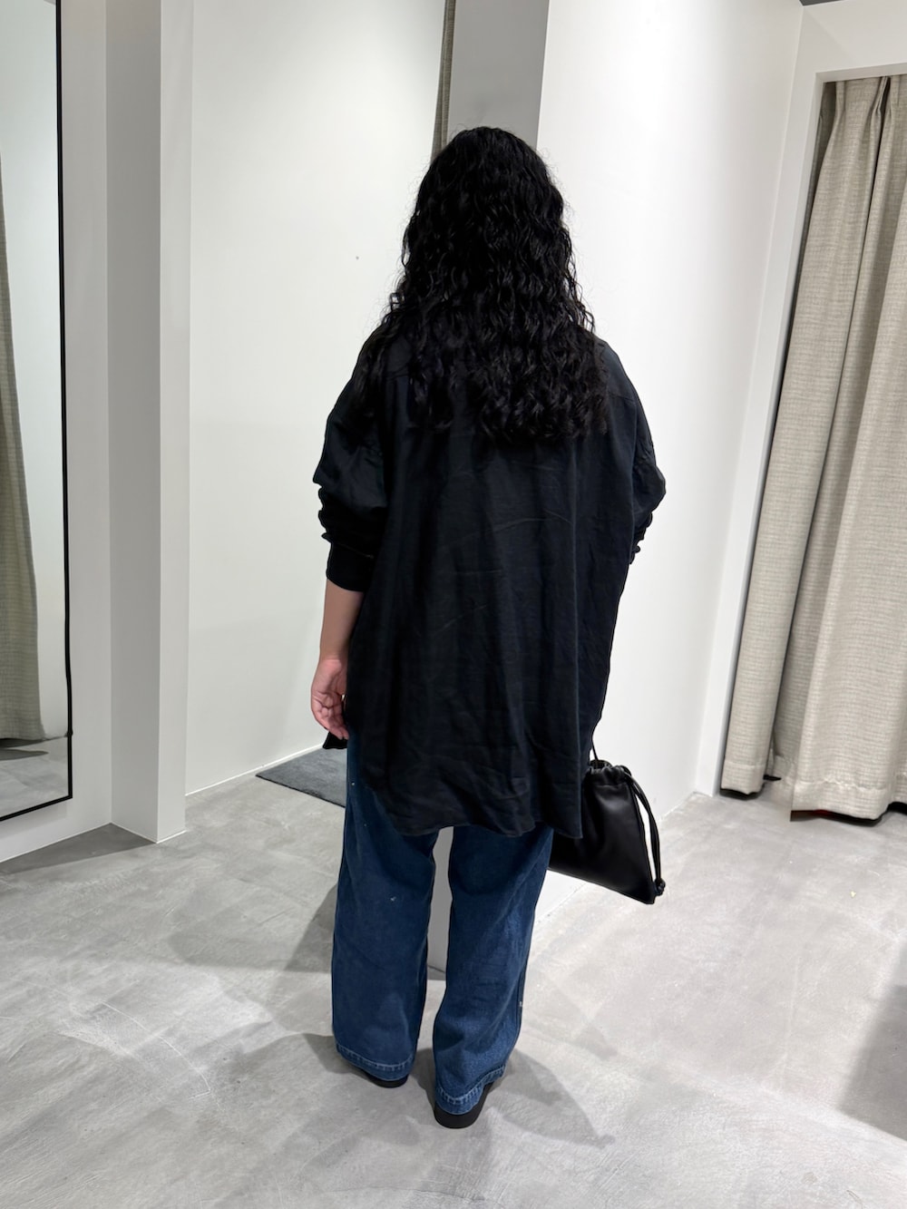 ブルー系のデニムパンツ、ブラック系のTシャツ/カットソー、シルバー系のネックレスを着用したレディースの夏コーディネートの3枚目の写真