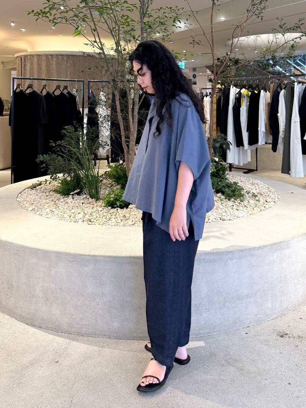 ブルー系のデニムパンツ、グレー系のシャツ/ブラウス、ブラック系のバッグを着用したレディースの夏コーディネートの2枚目の写真