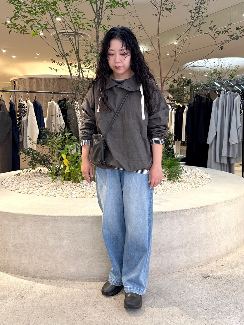 ブラック系のショルダーバッグ、ブルー系のデニムパンツ、グレー系のTシャツ/カットソーを着用したレディースの秋コーディネートの4枚目の写真