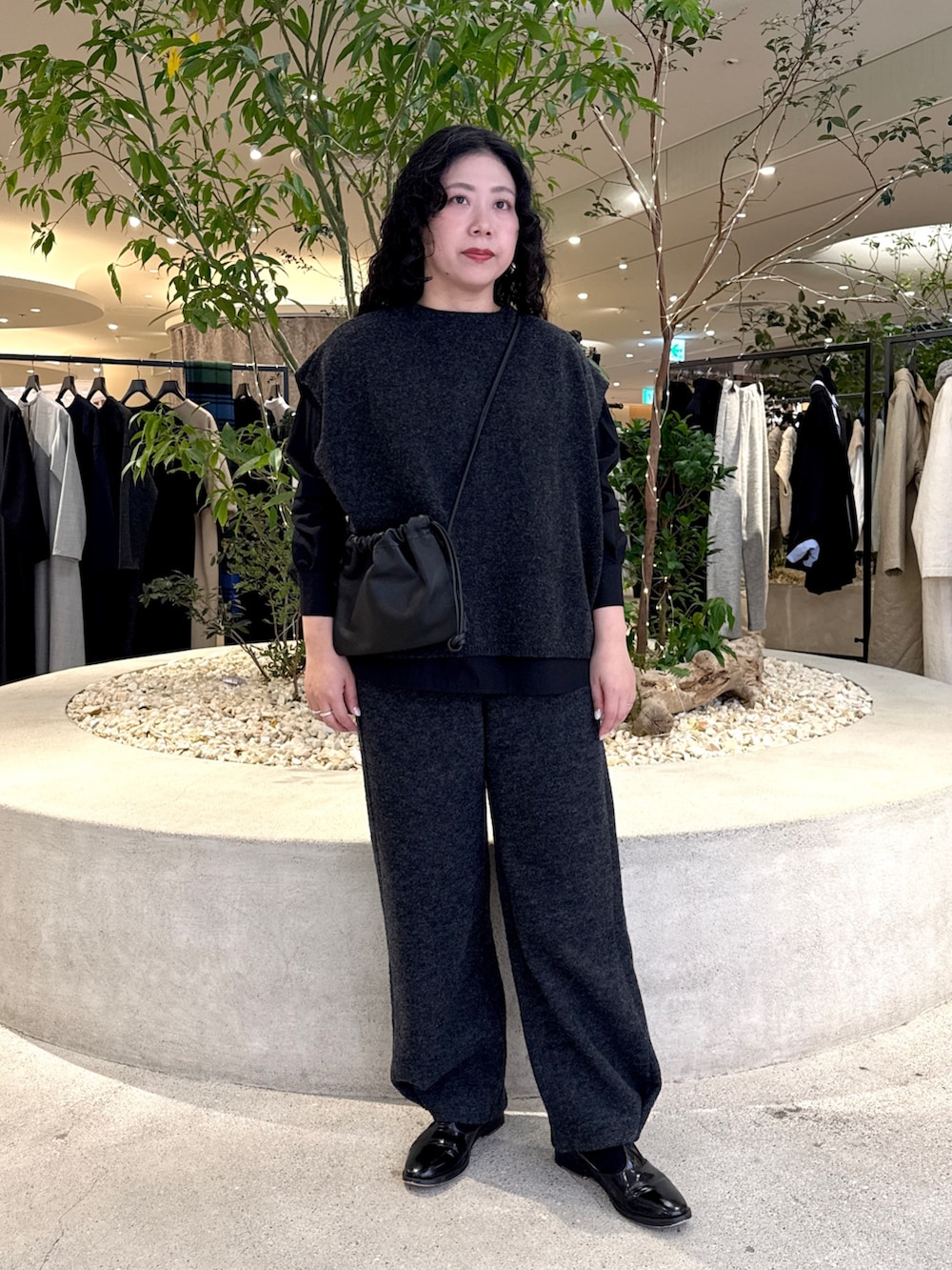 ブラック系のショルダーバッグ、ブラック系のシャツ/ブラウス、グレー系のその他パンツを着用したレディースの冬コーディネートの5枚目の写真