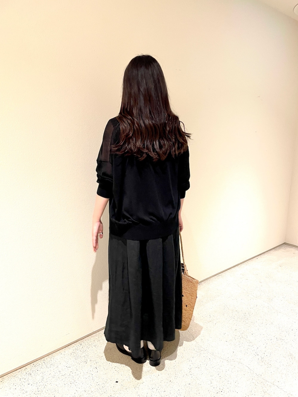 ブラック系のワンピース、ブラック系のカーディガン/ボレロ、ベージュ系のかごバッグを着用したレディースの夏コーディネートの2枚目の写真