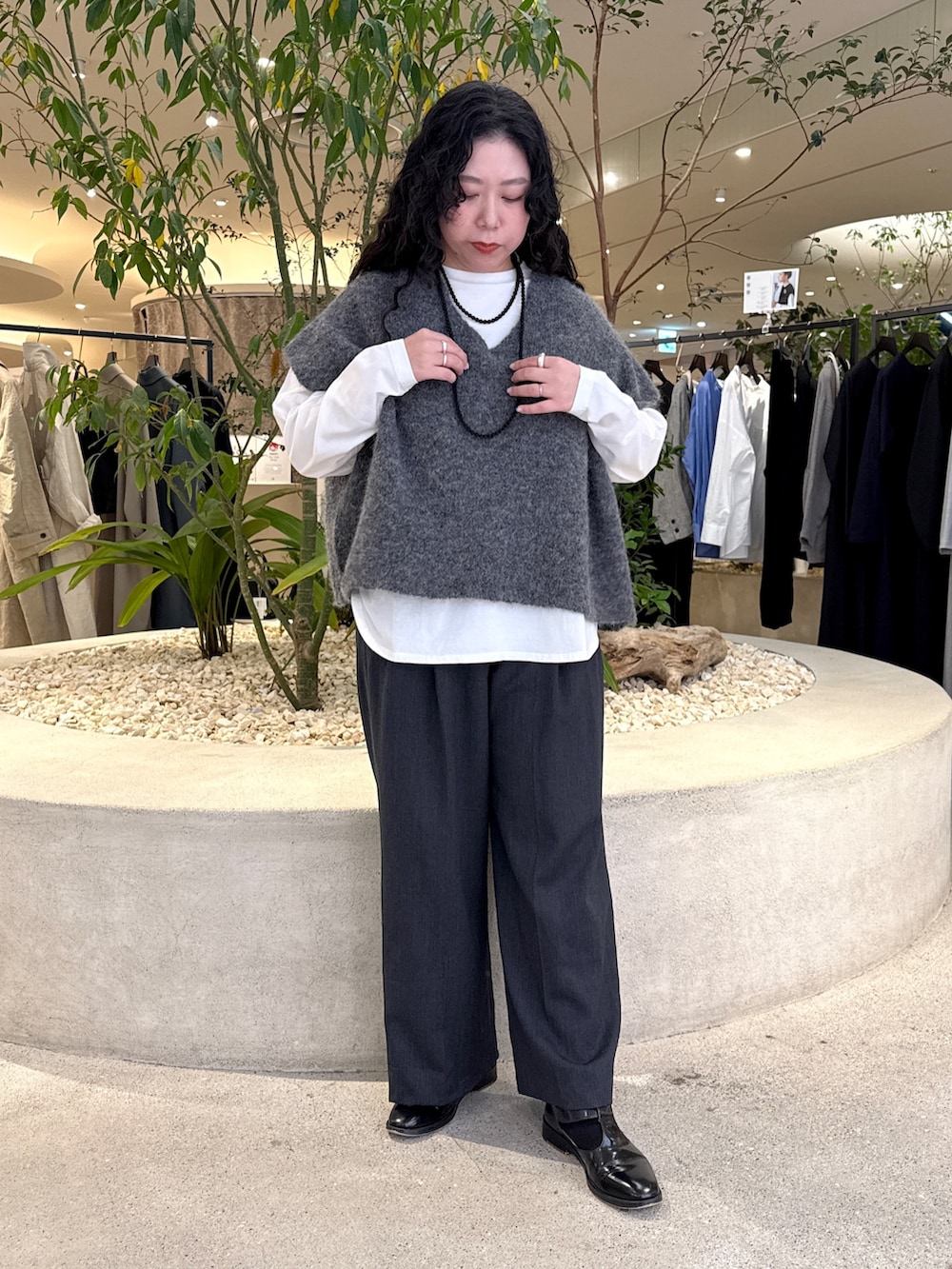 ホワイト系のTシャツ/カットソー、グレー系のその他パンツ、グレー系のベストを着用したレディースの冬コーディネートの5枚目の写真