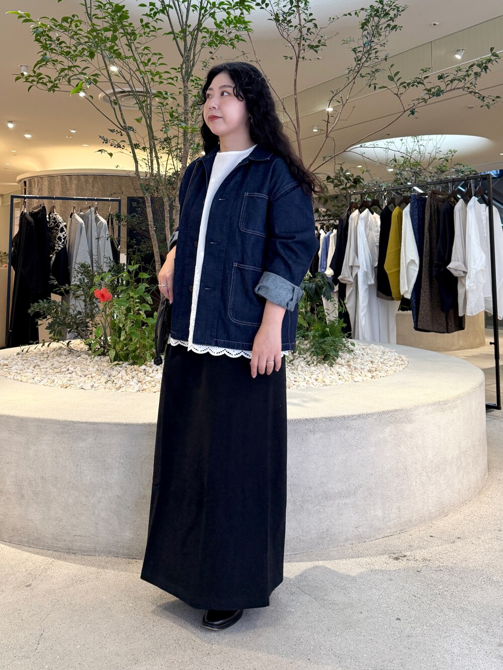 ブルー系のカバーオール、ブラック系のショルダーバッグ、ブラック系のスカートを着用したレディースの秋コーディネートの4枚目の写真