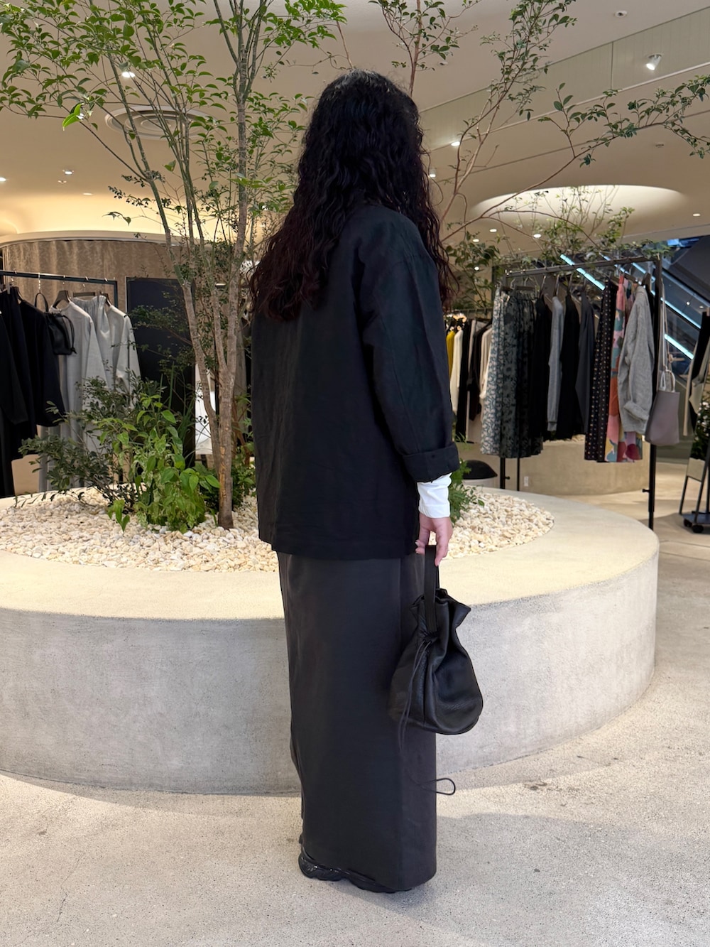 ホワイト系のTシャツ/カットソー、ブラック系のその他アウター、グレー系のスカートを着用したレディースの秋コーディネートの2枚目の写真