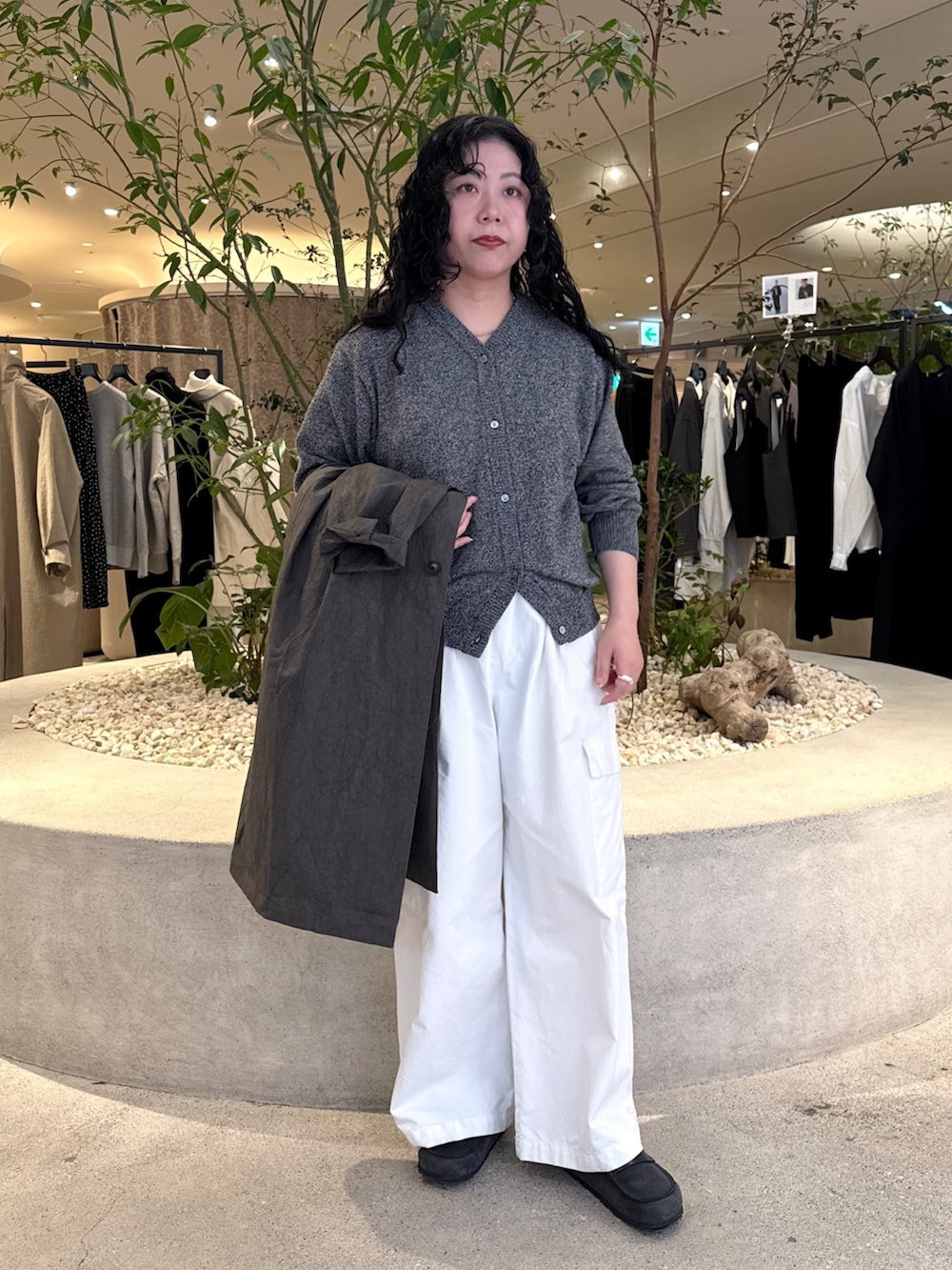 グレー系のニット/セーター、グレー系のその他アウター、ホワイト系のその他パンツを着用したレディースの冬コーディネートの6枚目の写真