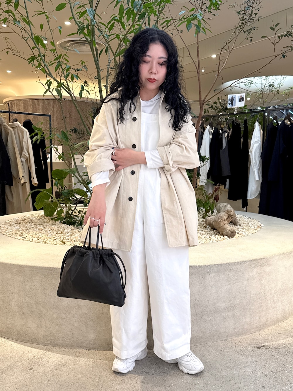 ブラック系のバッグ、ホワイト系のTシャツ/カットソー、ホワイト系のその他アウターを着用したレディースの冬コーディネートの2枚目の写真