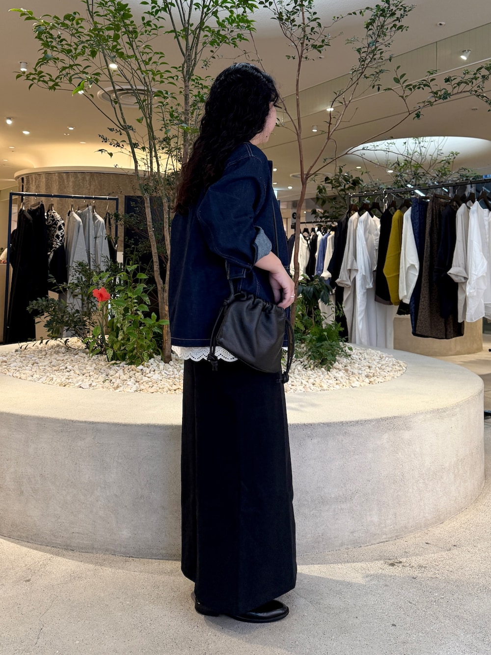 ブルー系のカバーオール、ブラック系のショルダーバッグ、ブラック系のスカートを着用したレディースの秋コーディネートの2枚目の写真