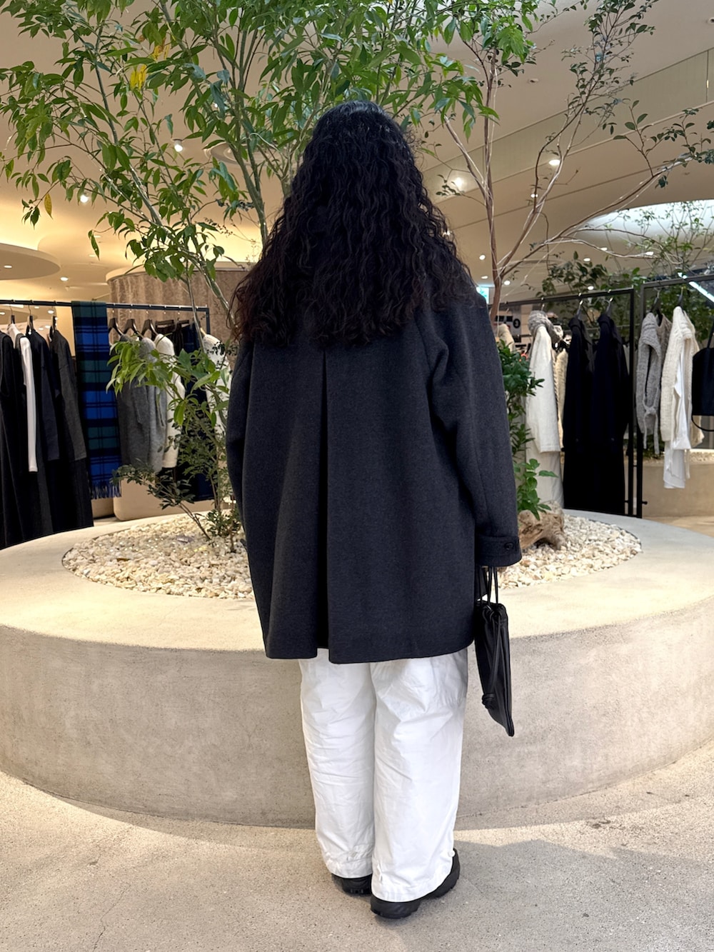 ブラック系のバッグ、グリーン系のステンカラーコート、ブルー系のその他トップスを着用したレディースの冬コーディネートの3枚目の写真