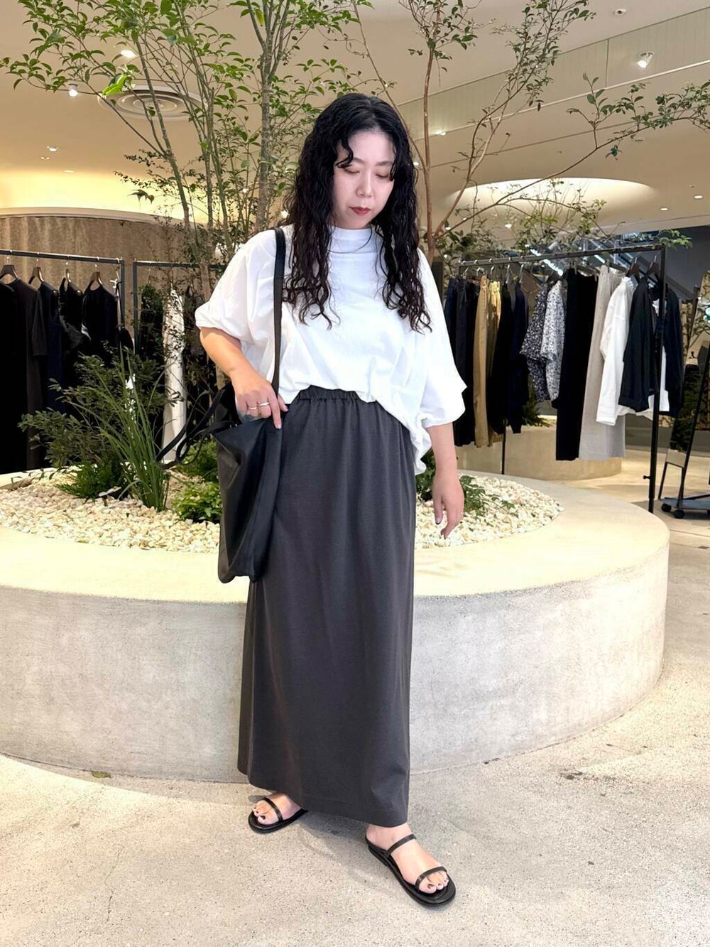 ホワイト系のTシャツ/カットソー、グレー系のスカート、ブラック系のバッグを着用したレディースの夏コーディネートの5枚目の写真