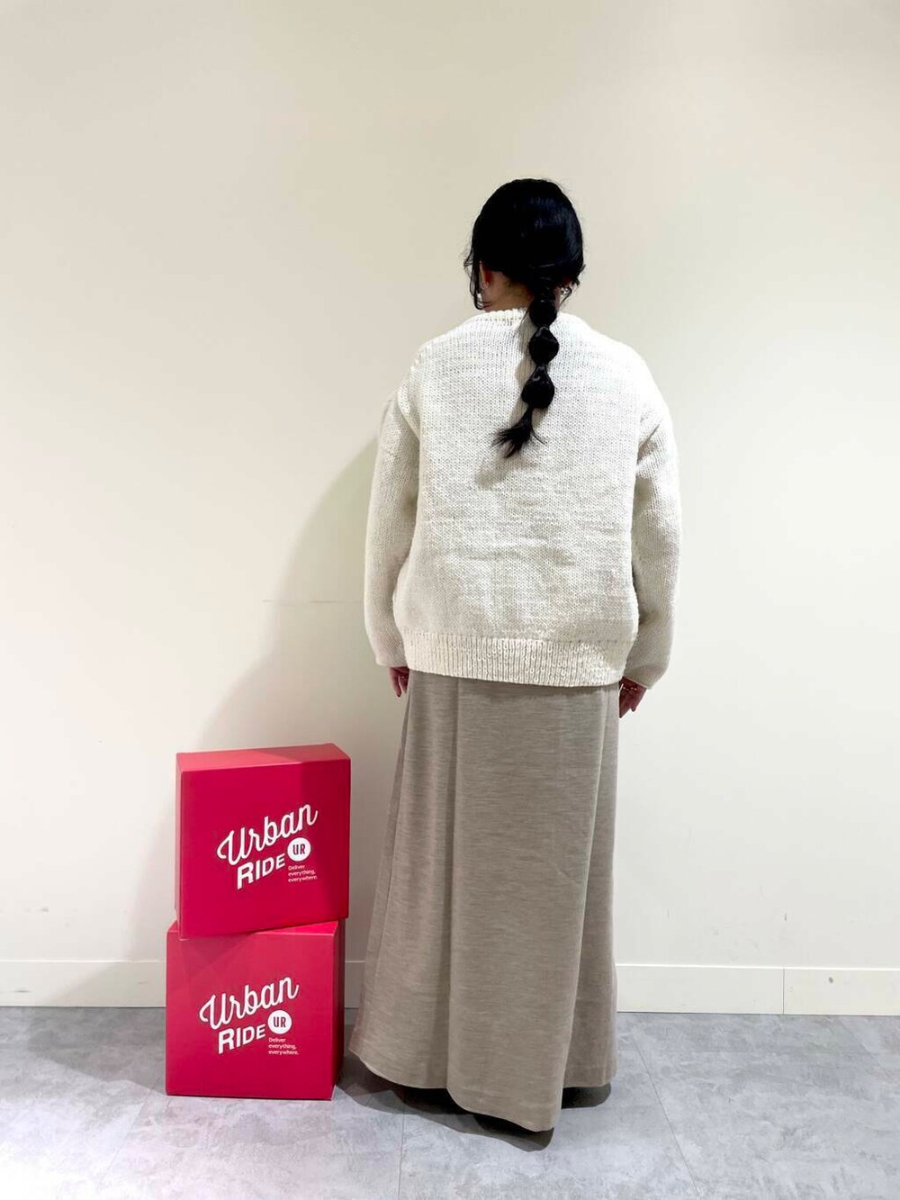 ホワイト系のニット/セーター、ブラック系のTシャツ/カットソー、ベージュ系のスカートを着用したレディースの冬コーディネートの5枚目の写真
