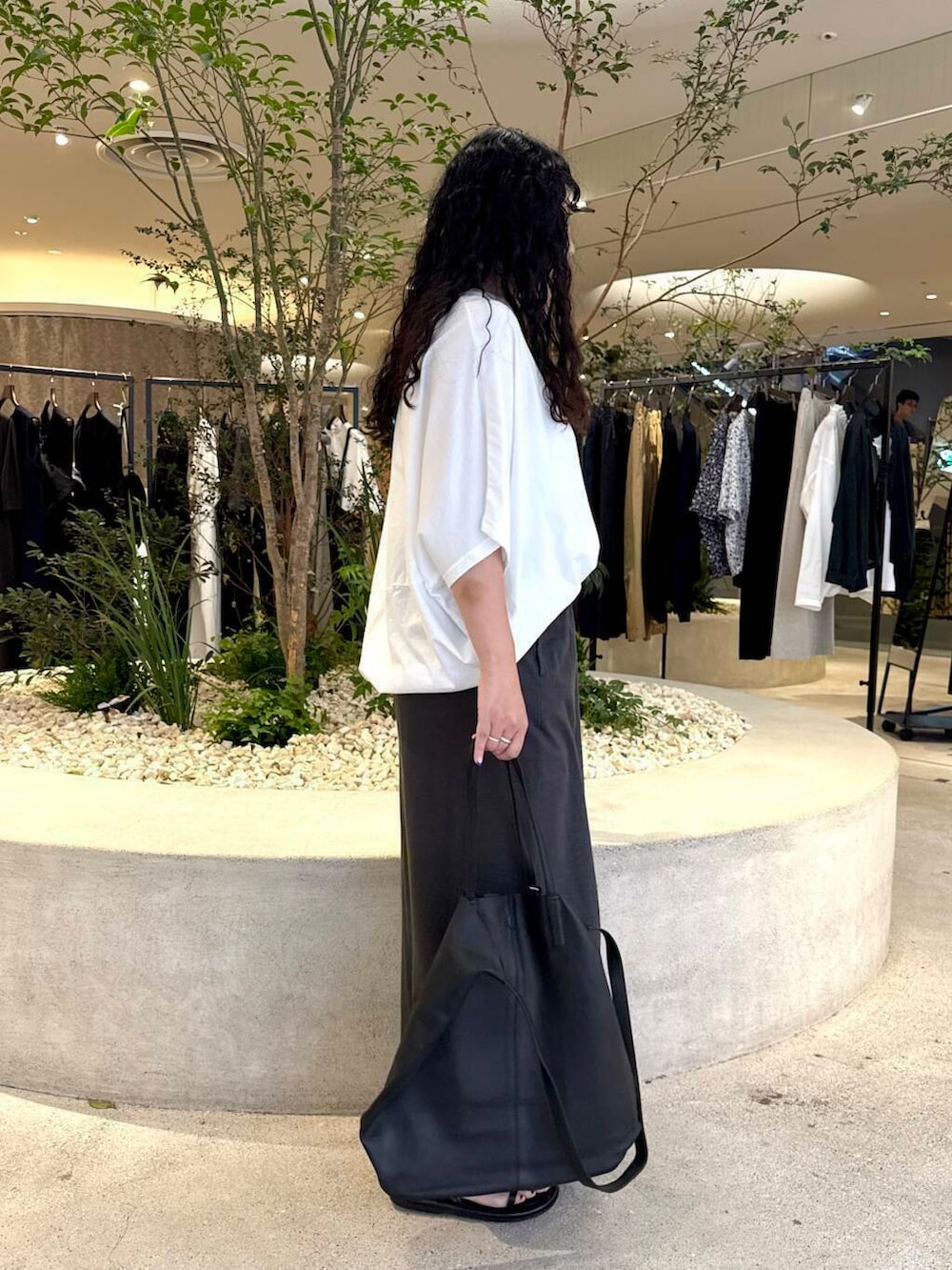 ホワイト系のTシャツ/カットソー、グレー系のスカート、ブラック系のバッグを着用したレディースの夏コーディネートの2枚目の写真