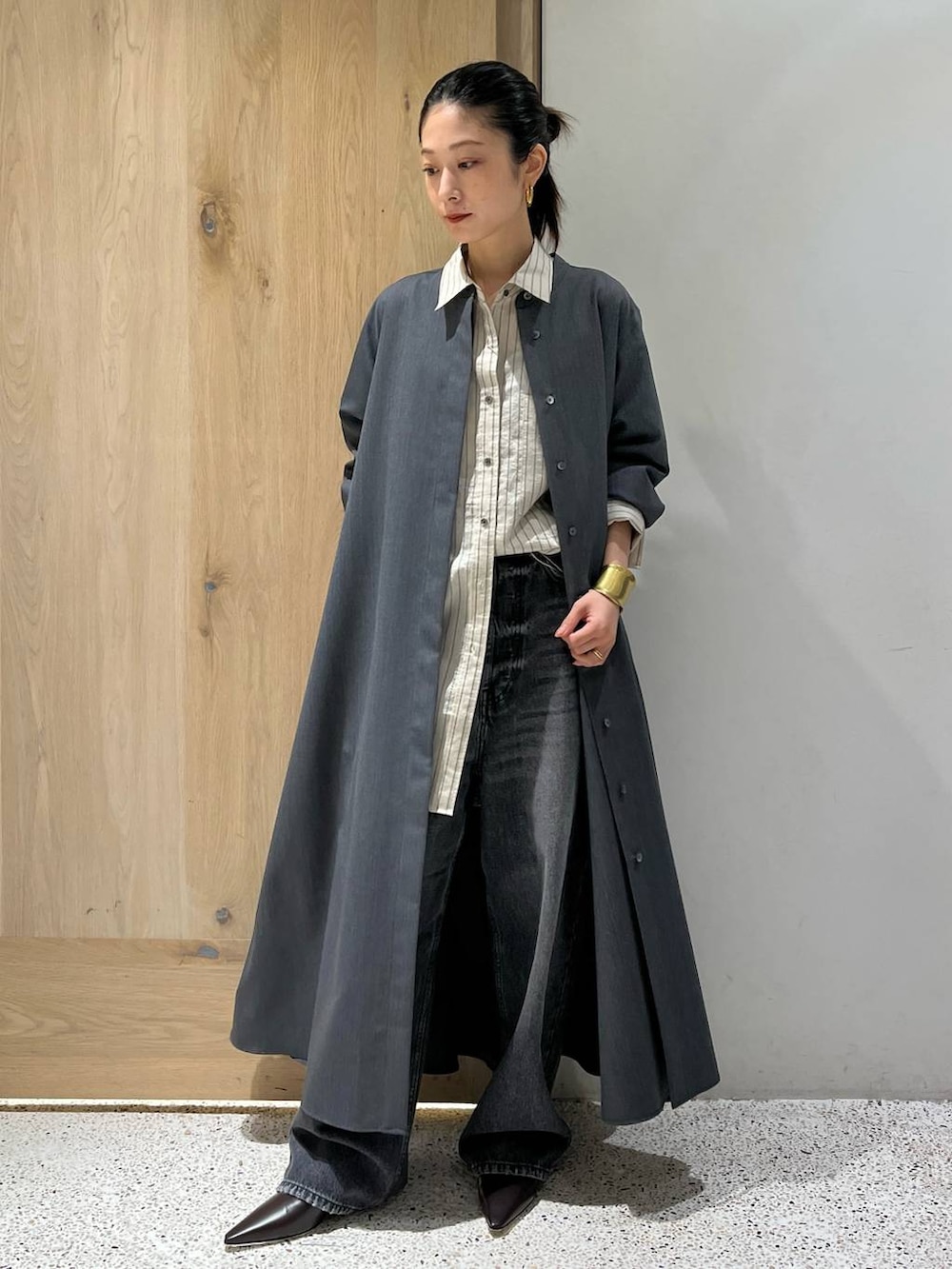 ブラック系のデニムパンツ、グレー系のワンピース、ホワイト系のシャツ/ブラウスを着用したレディースの秋コーディネートの3枚目の写真