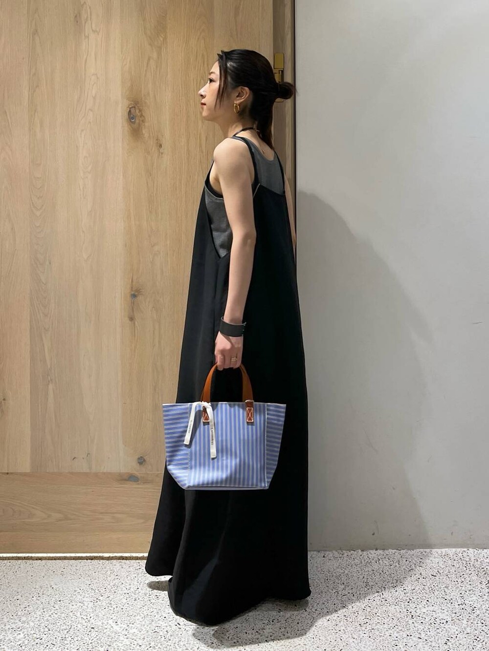 グレー系のタンクトップ、ブラック系のサンダル、ブラック系のワンピースを着用したレディースの夏コーディネートの4枚目の写真