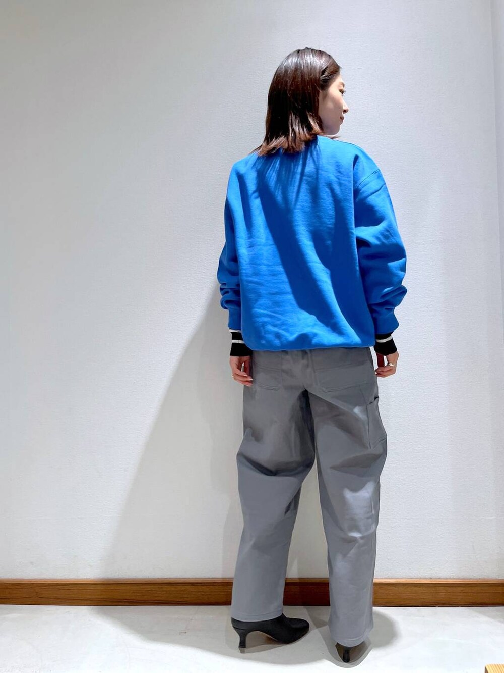 ブラック系のニット/セーター、ブラック系のブーツ、グレー系のノーカラージャケットを着用したレディースの秋コーディネートの7枚目の写真