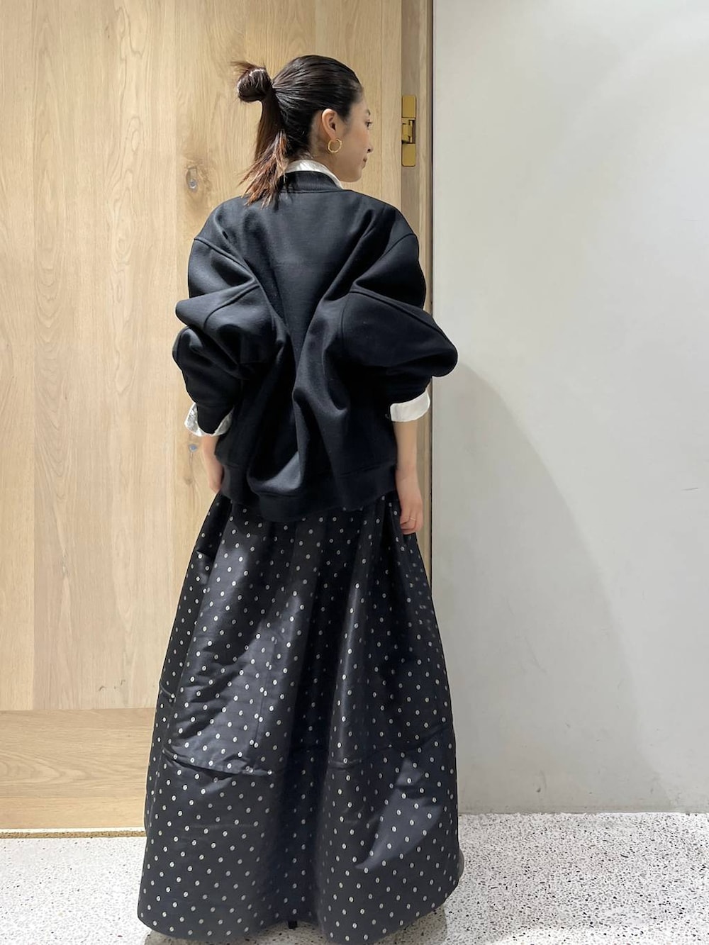 ブラック系のスカート、ブラック系のブルゾン、ホワイト系のシャツ/ブラウスを着用したレディースの秋コーディネートの5枚目の写真