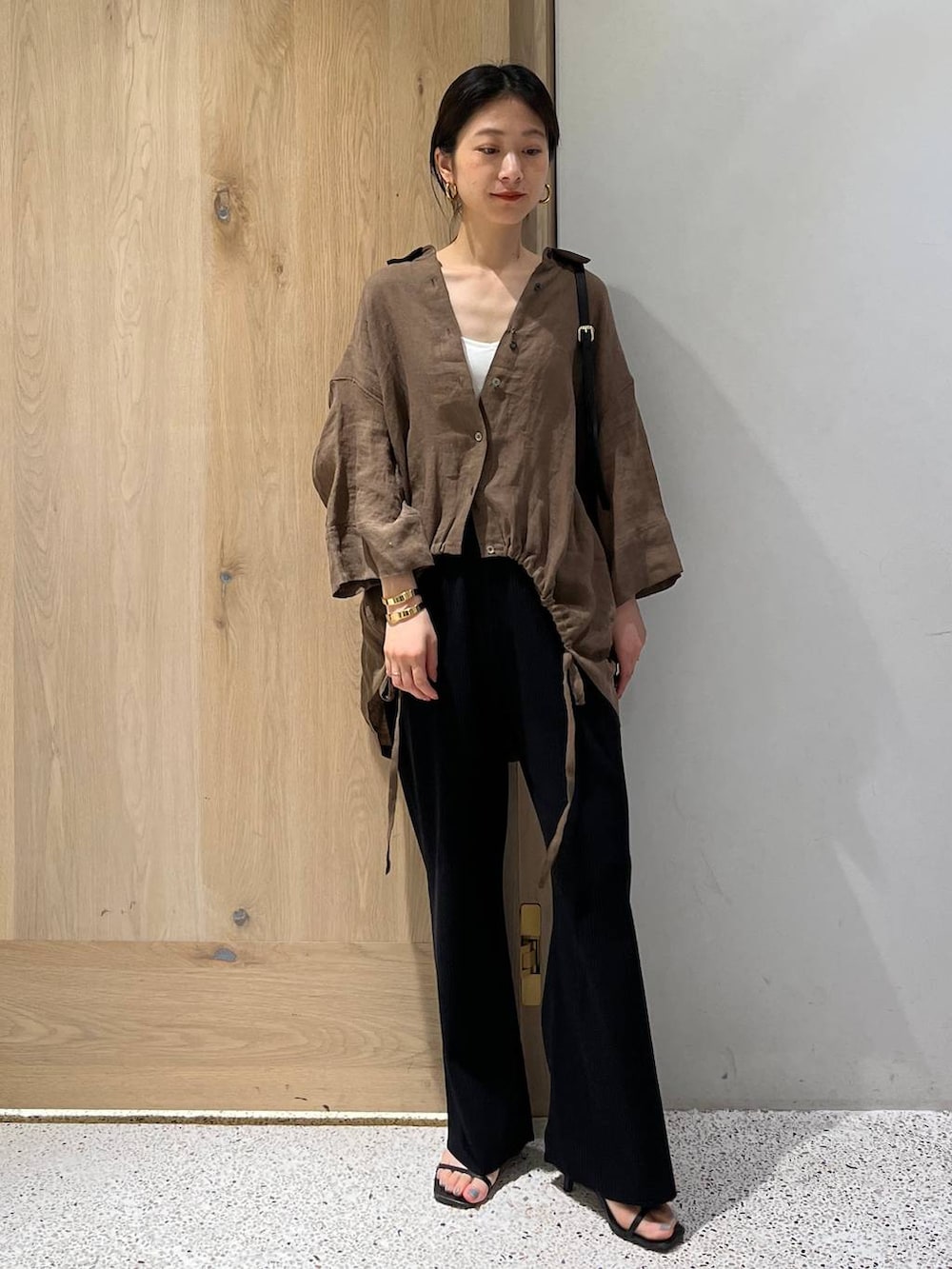 ブラック系のその他パンツ、ブラウン系のシャツ/ブラウス、ゴールド系のバングル/リストバンドを着用したレディースの春コーディネートの6枚目の写真