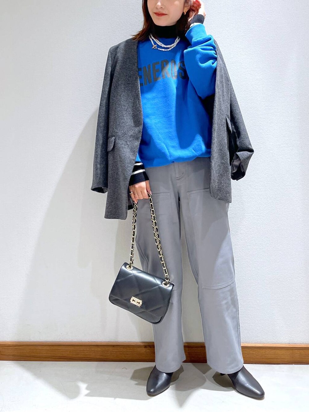 ブラック系のニット/セーター、ブラック系のブーツ、グレー系のノーカラージャケットを着用したレディースの秋コーディネートの8枚目の写真