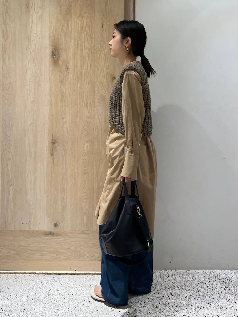 ブルー系のデニムパンツ、ベージュ系のベスト、ベージュ系のシャツ/ブラウスを着用したレディースの春コーディネートの3枚目の写真