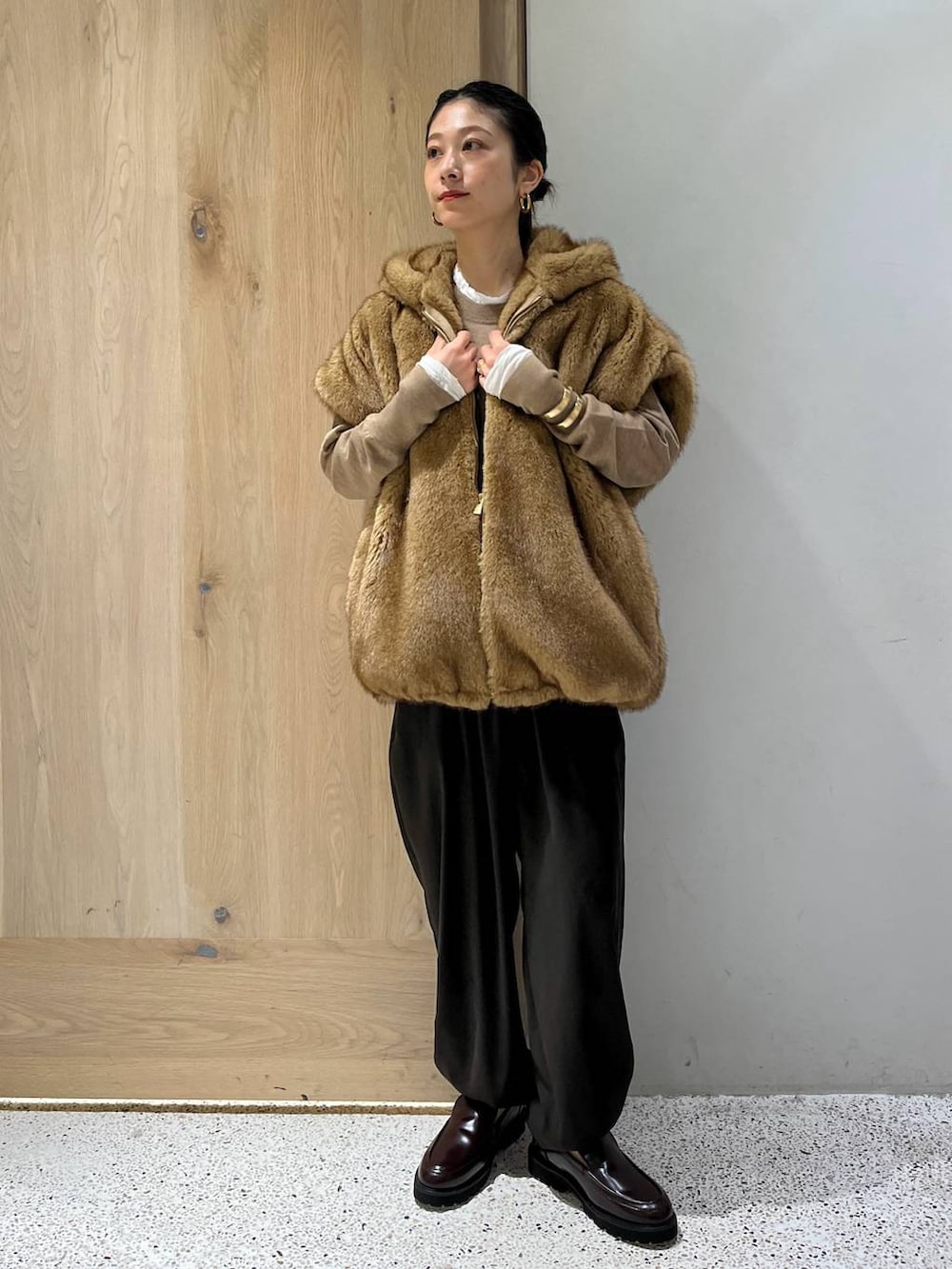 ホワイト系のTシャツ/カットソー、ベージュ系のベスト、ブラウン系のニット/セーターを着用したレディースの秋コーディネートの3枚目の写真