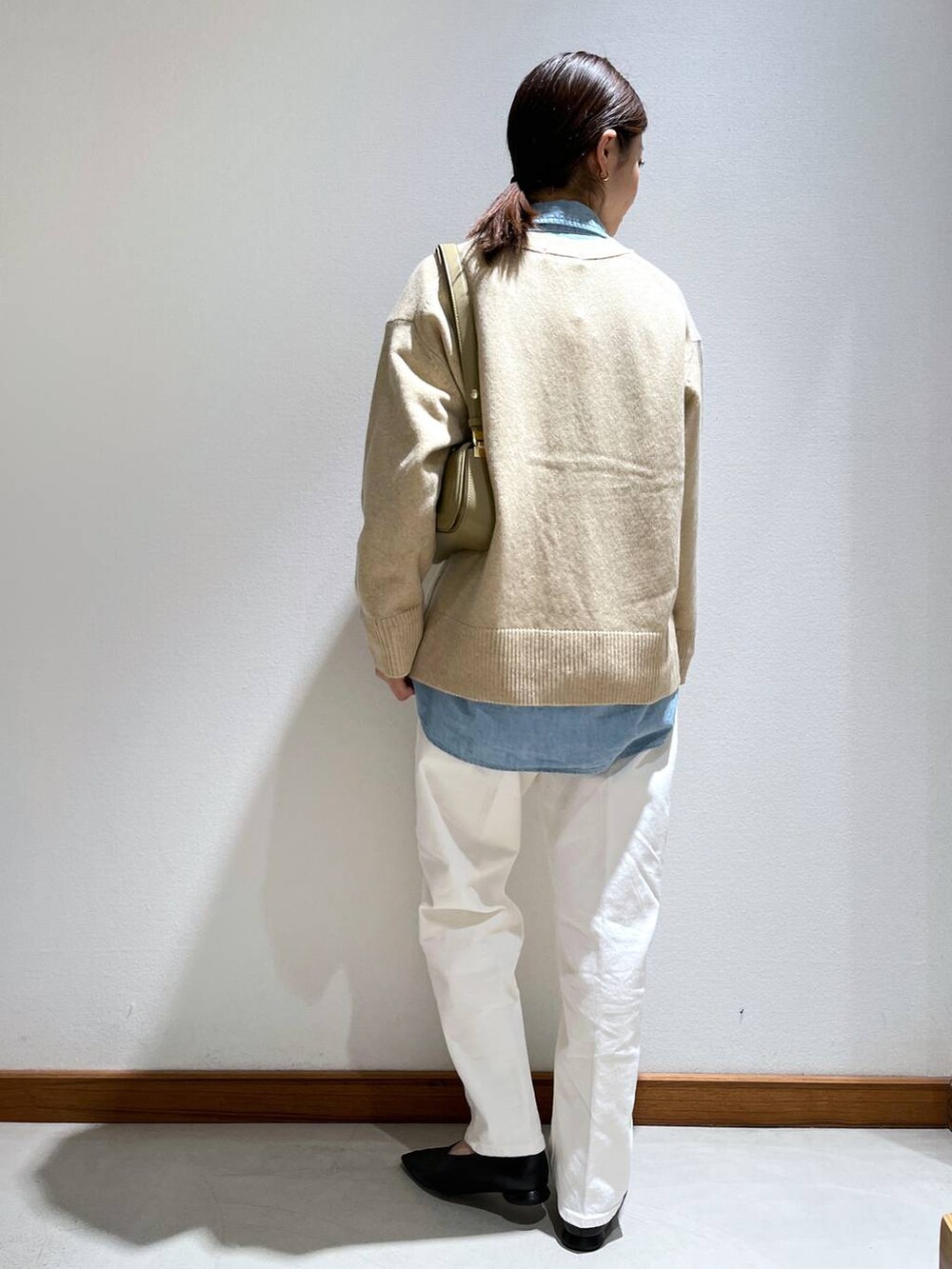 ブラック系のパンプス、ベージュ系のショルダーバッグ、ベージュ系のカーディガン/ボレロを着用したレディースの冬コーディネートの4枚目の写真