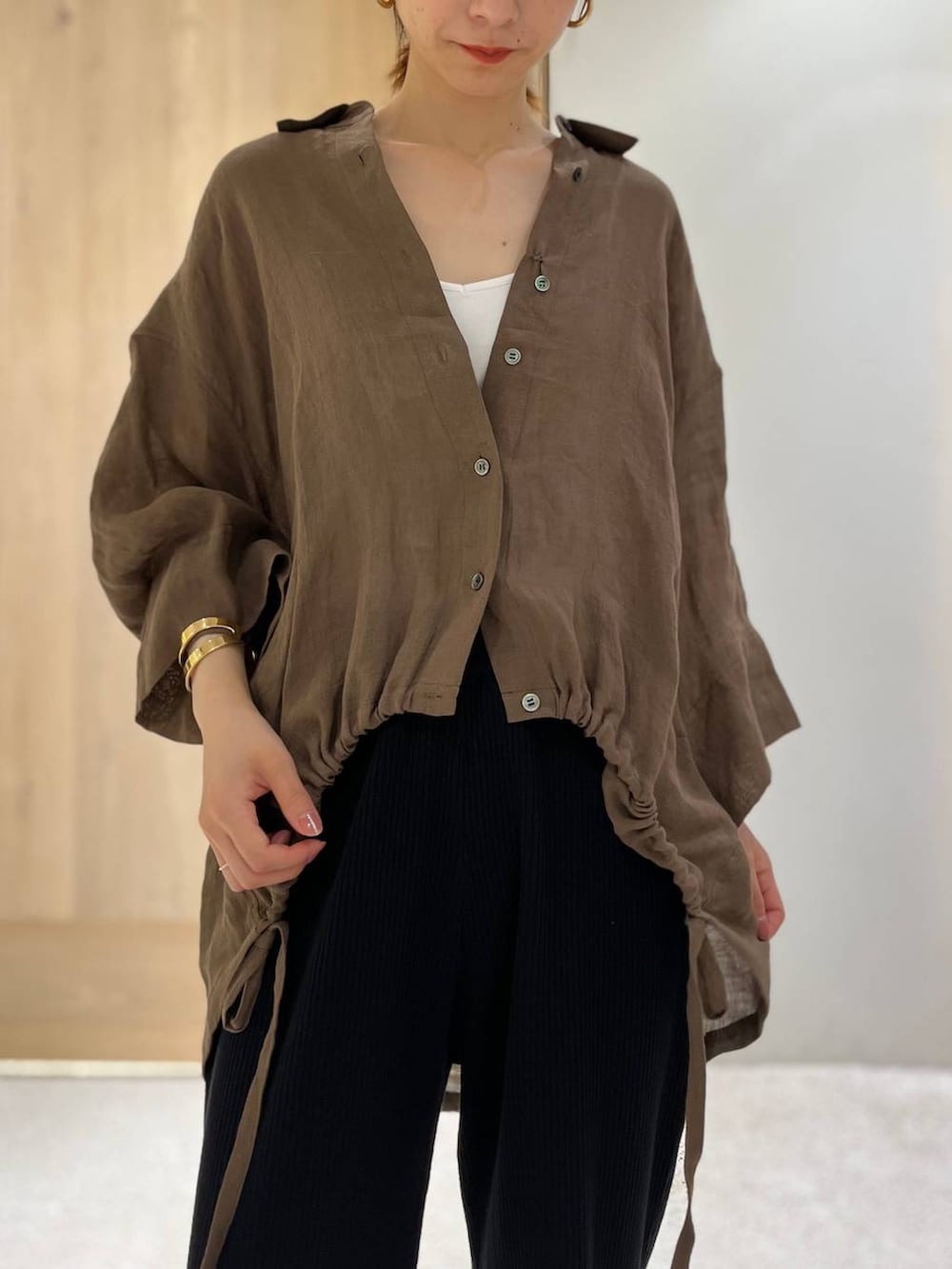 ブラック系のその他パンツ、ブラウン系のシャツ/ブラウス、ゴールド系のバングル/リストバンドを着用したレディースの春コーディネートの5枚目の写真