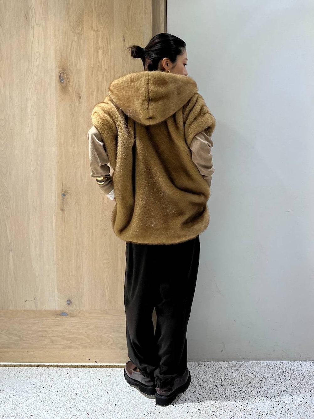 ホワイト系のTシャツ/カットソー、ベージュ系のベスト、ブラウン系のニット/セーターを着用したレディースの秋コーディネートの5枚目の写真