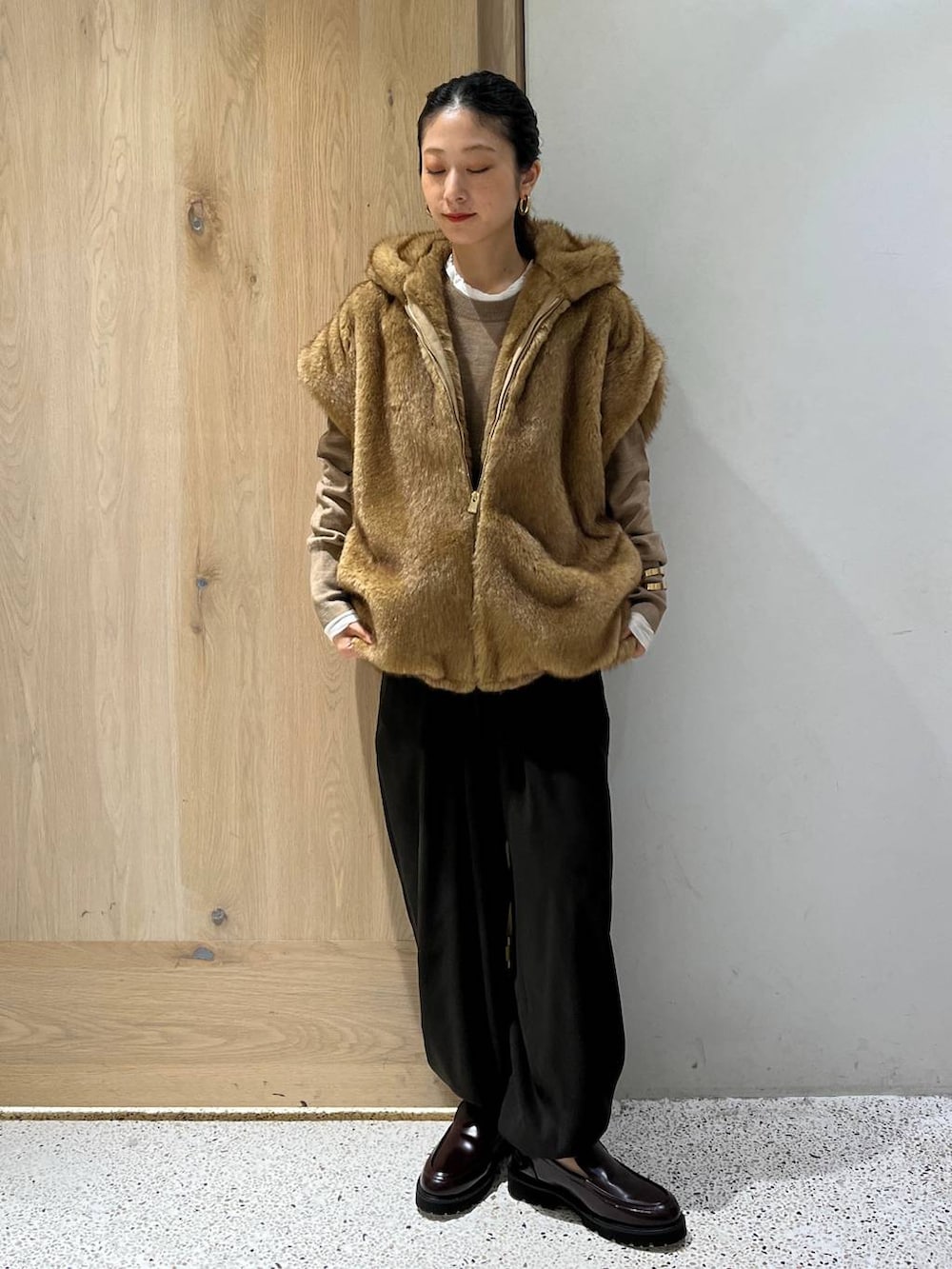 ホワイト系のTシャツ/カットソー、ベージュ系のベスト、ブラウン系のニット/セーターを着用したレディースの秋コーディネートの8枚目の写真