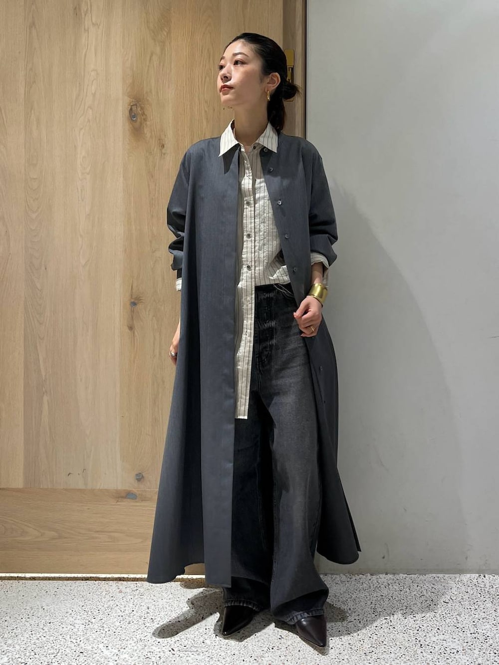 ブラック系のデニムパンツ、グレー系のワンピース、ホワイト系のシャツ/ブラウスを着用したレディースの秋コーディネートの2枚目の写真