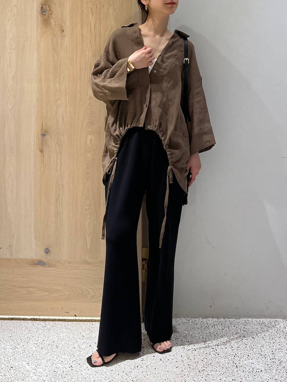 ブラック系のその他パンツ、ブラウン系のシャツ/ブラウス、ゴールド系のバングル/リストバンドを着用したレディースの春コーディネートの2枚目の写真