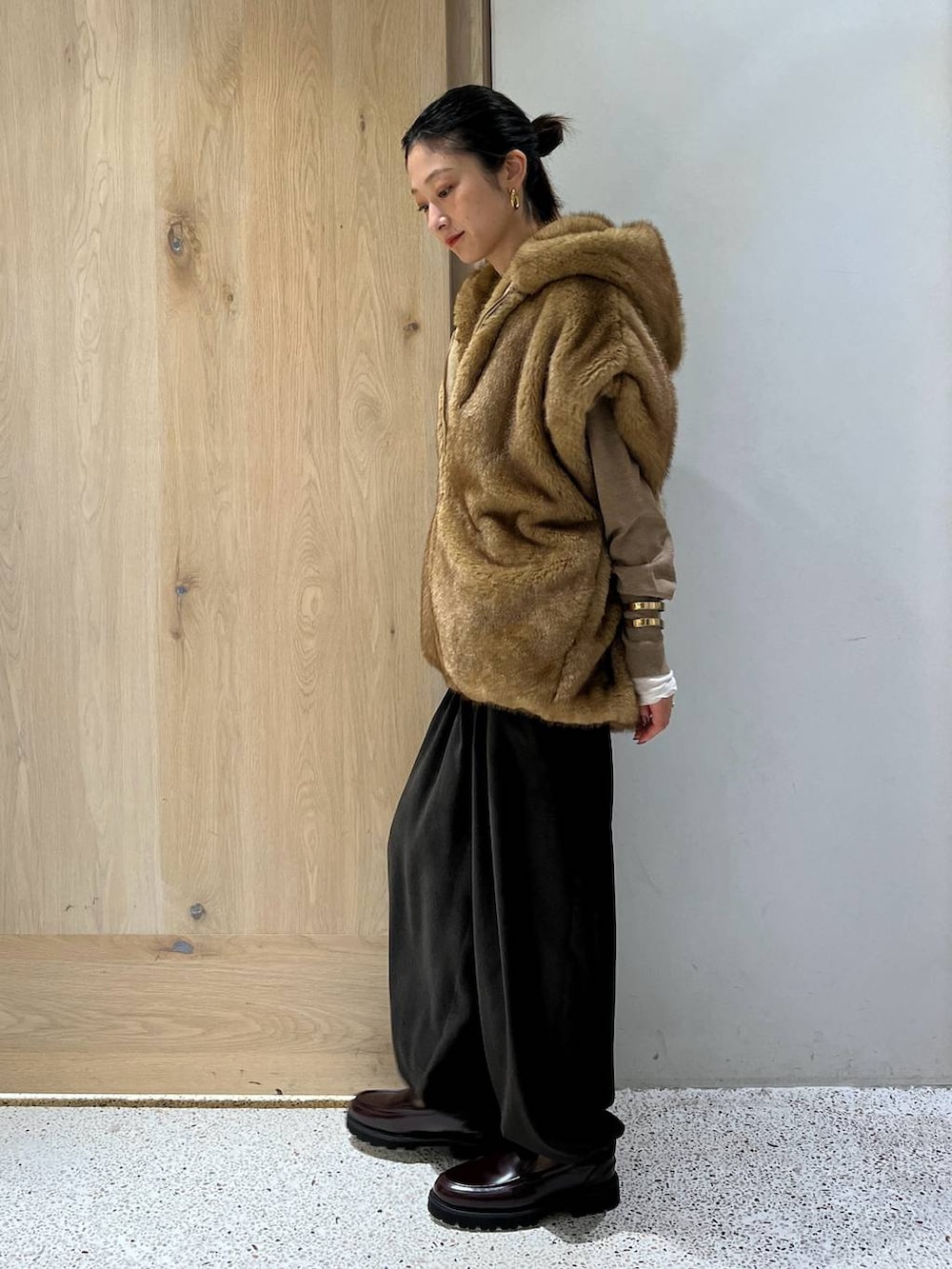 ホワイト系のTシャツ/カットソー、ベージュ系のベスト、ブラウン系のニット/セーターを着用したレディースの秋コーディネートの4枚目の写真