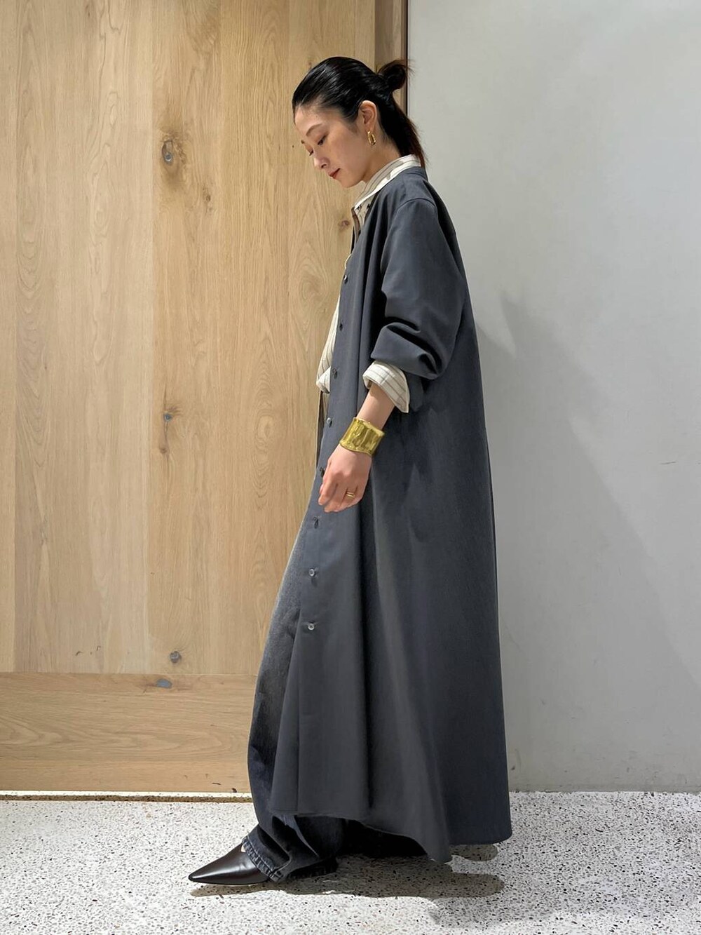 ブラック系のデニムパンツ、グレー系のワンピース、ホワイト系のシャツ/ブラウスを着用したレディースの秋コーディネートの4枚目の写真